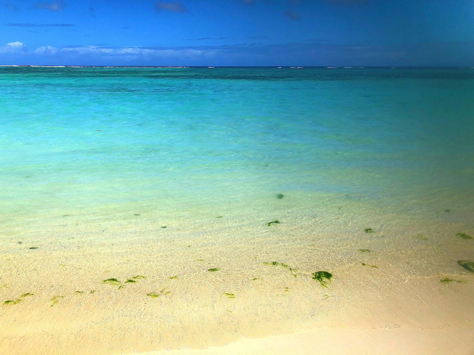 A scenic view of turquoise water and white sandy beach