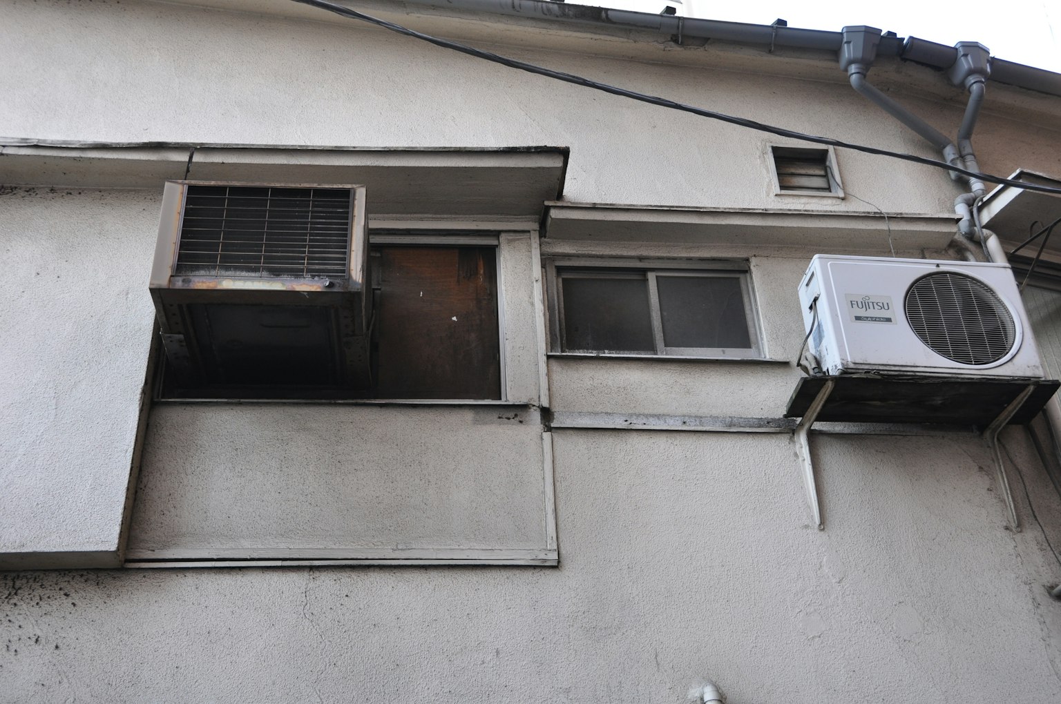 Esterno di un vecchio edificio con una finestra e un'unità di condizionamento