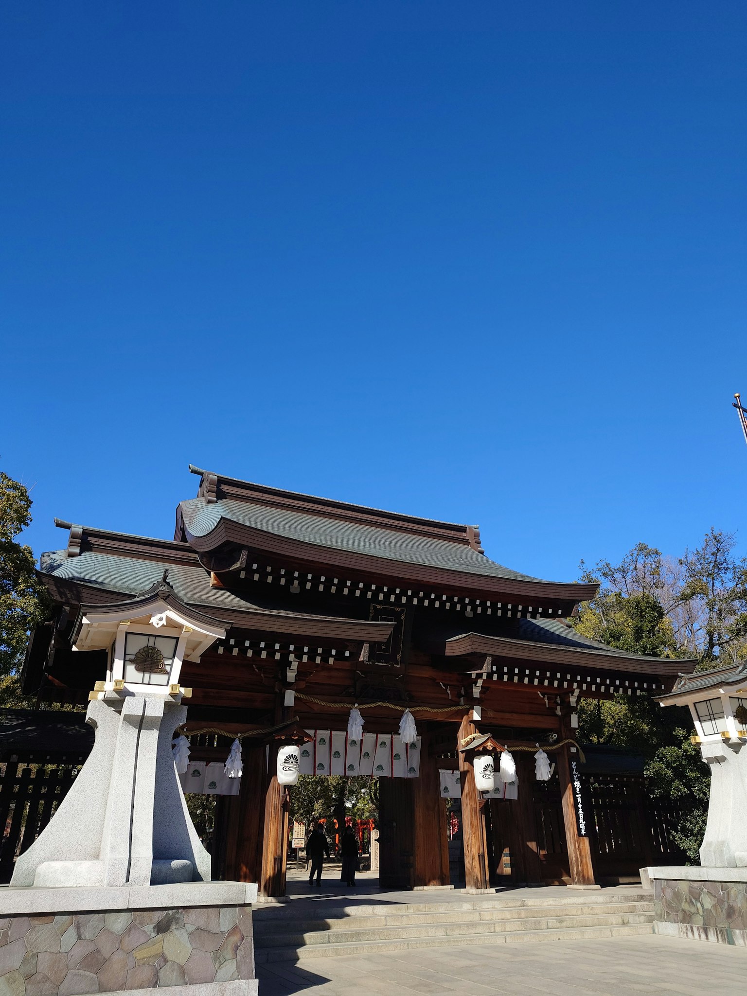 Traditional Japanese shrine gate under a clear blue sky