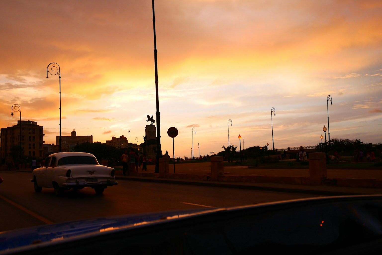 Cityscape featuring a sunset sky and a vintage car