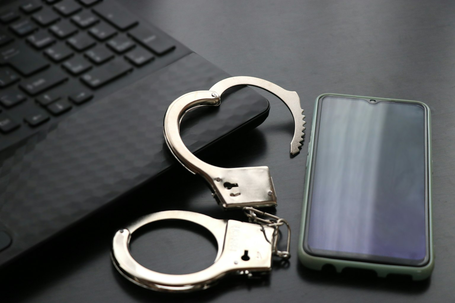 Manette a forma di cuore accanto a uno smartphone su una superficie nera