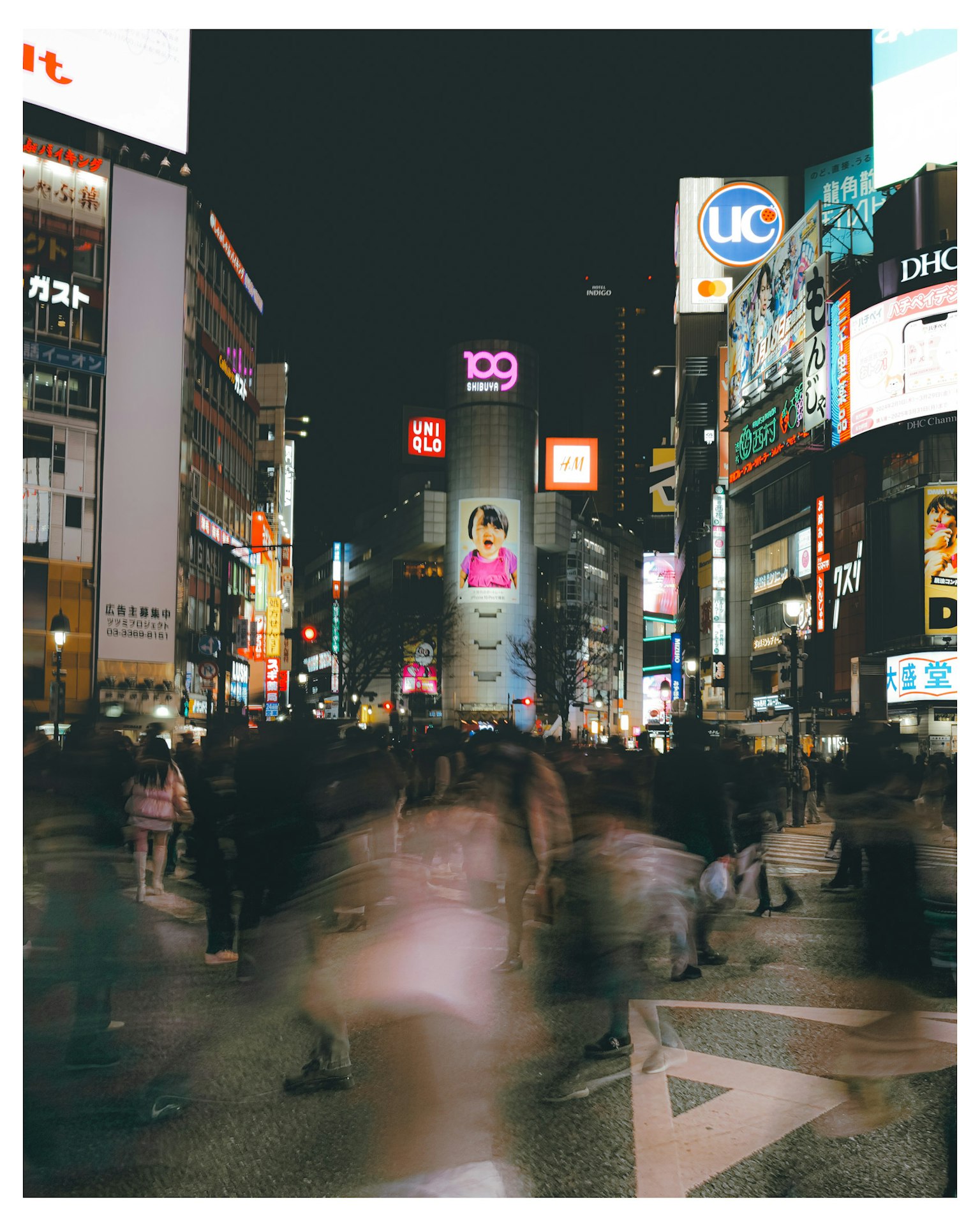 ถนนในเมืองที่พลุกพล่านในเวลากลางคืนพร้อมผู้คนและป้ายไฟนีออน