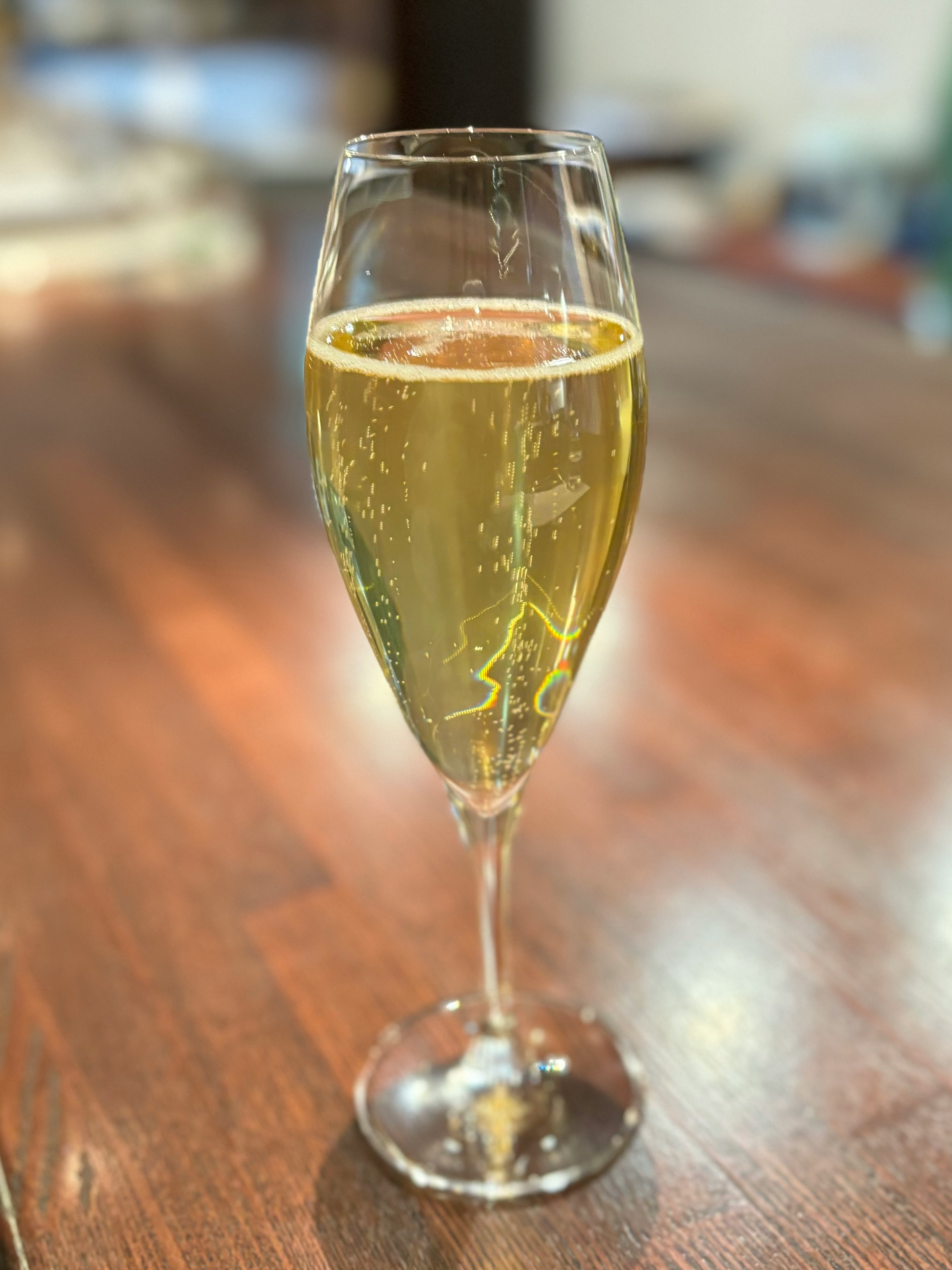木桌上的香檳酒杯與氣泡酒