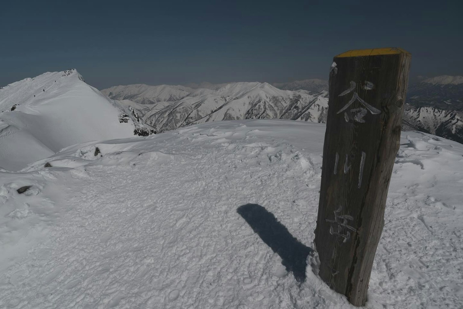Señal de cumbre nevada y montañas distantes