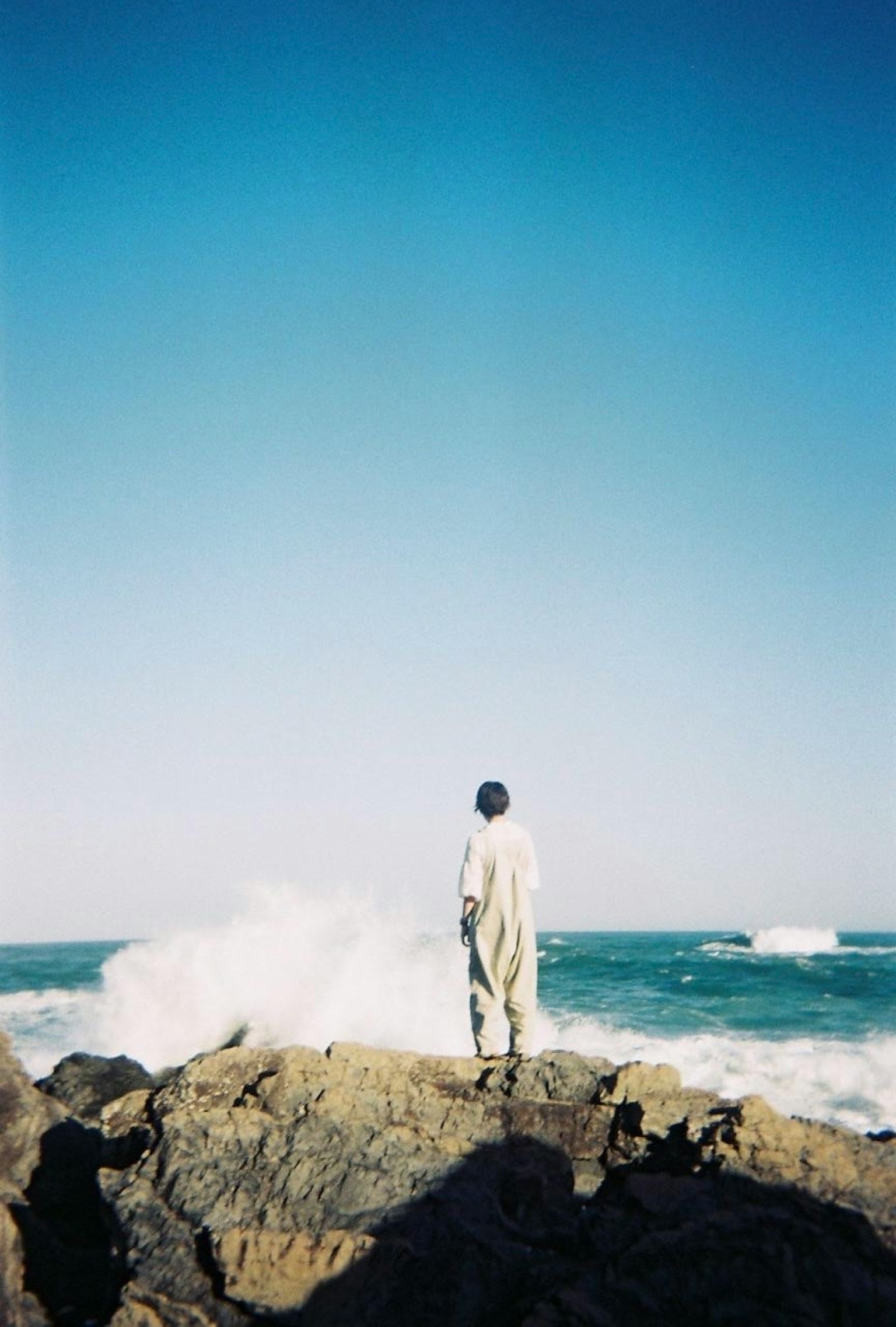站在岩石海岸上俯瞰海浪的人
