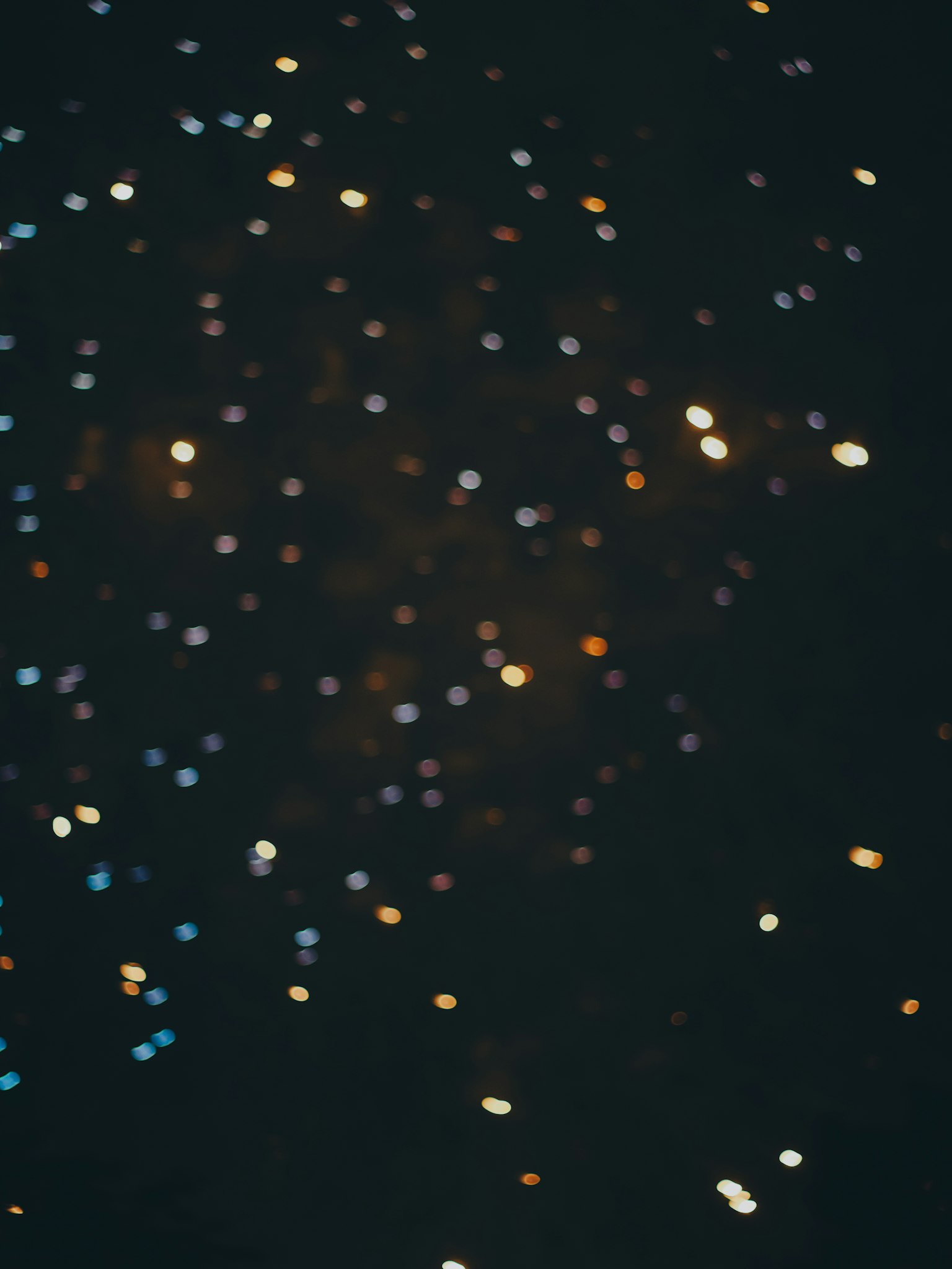 Puntos de luz coloridos esparcidos sobre un fondo oscuro