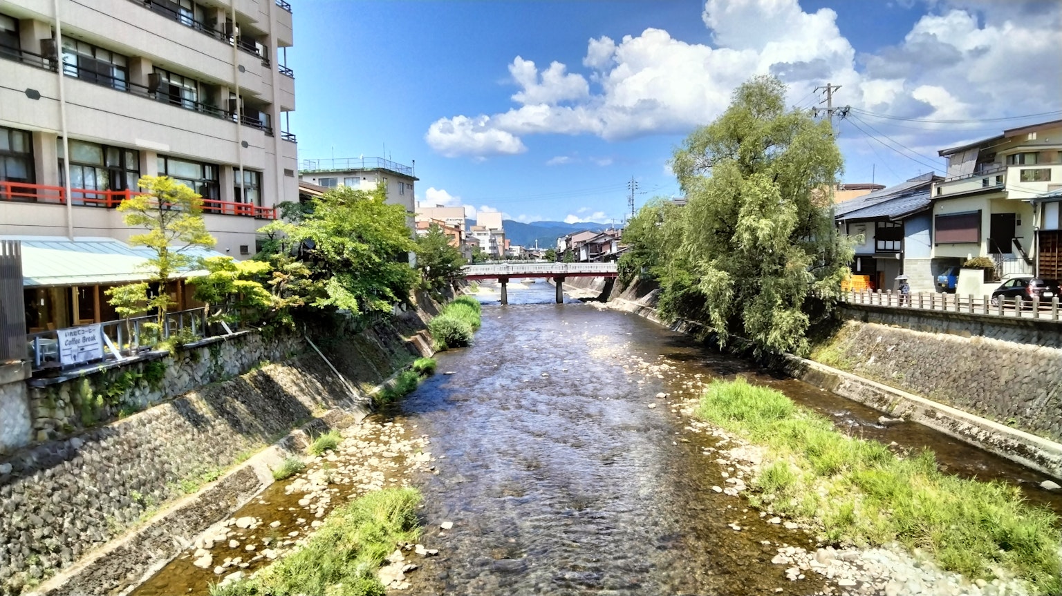 Scenic view of a river with blue sky and buildings along the banks