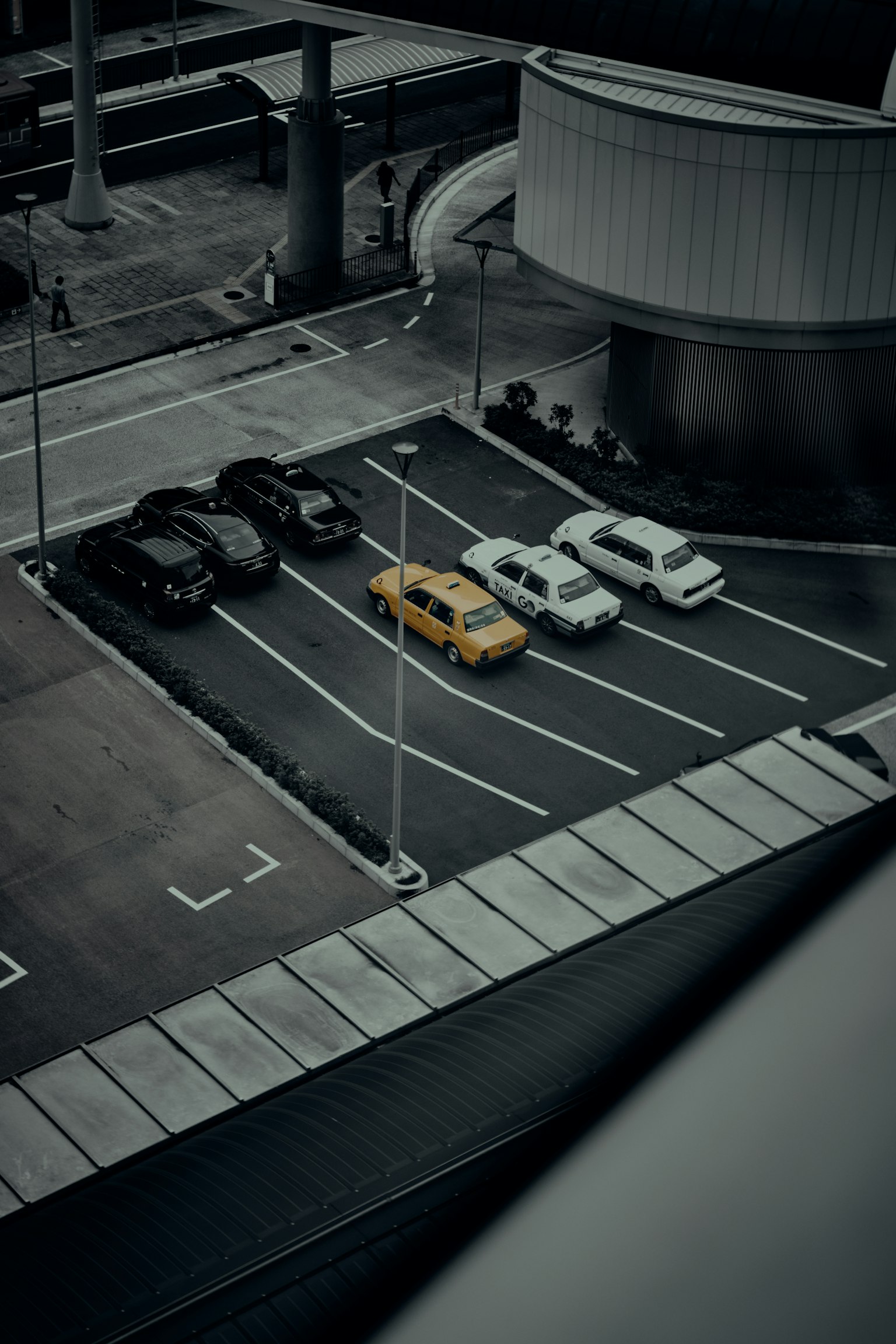 Cảnh từ trên cao của bãi đậu xe với một chiếc taxi màu vàng và một vài chiếc xe