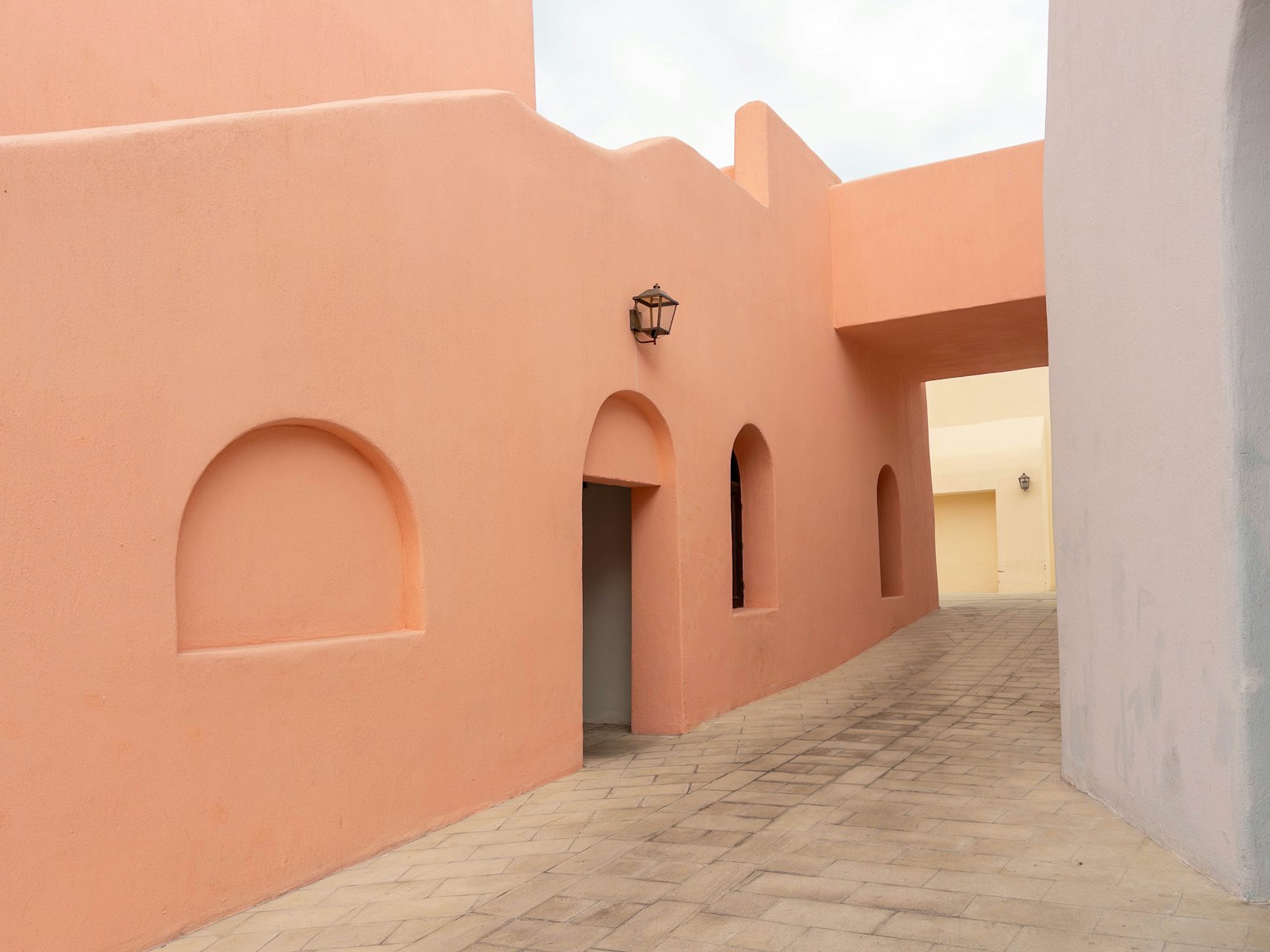 Extérieur d'un bâtiment avec des murs orange et un chemin courbé