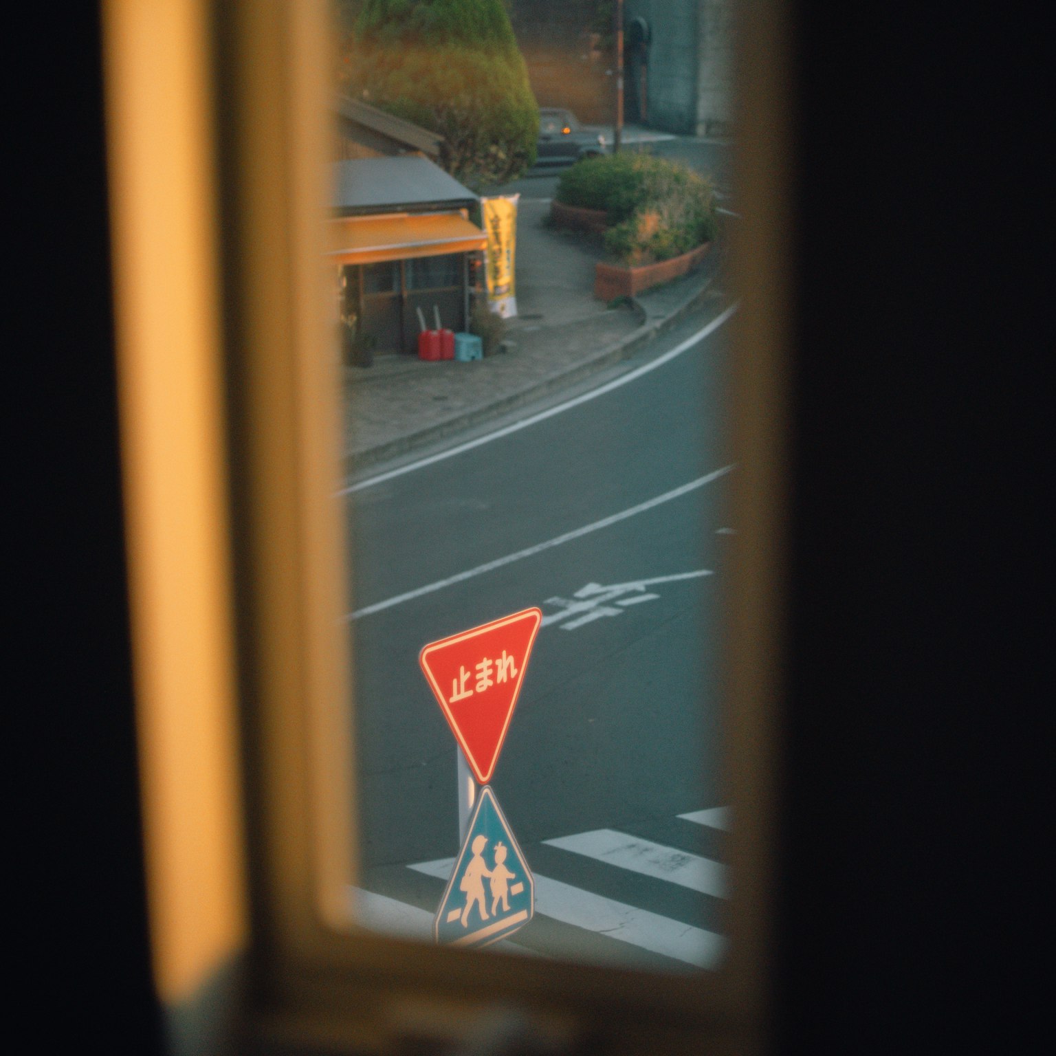 Vista de una intersección y una señal de tráfico a través de una ventana