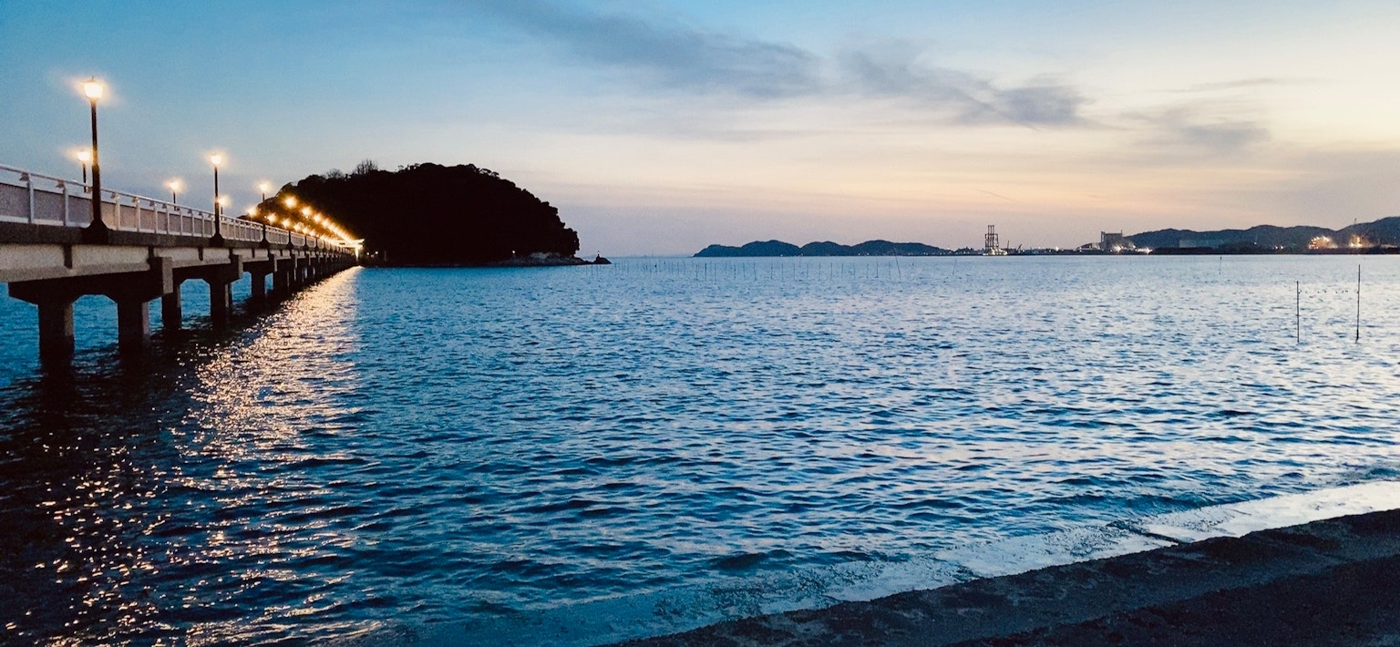 黃昏的海洋和碼頭景色，特色是島嶼和寧靜的水面