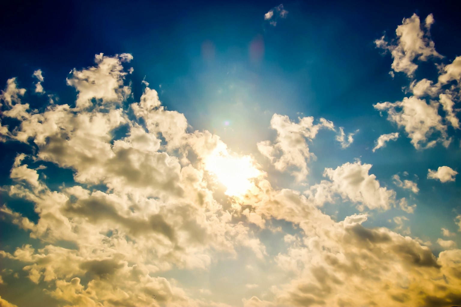 Ein blauer Himmel mit weißen Wolken und Sonnenlicht, das durchscheint