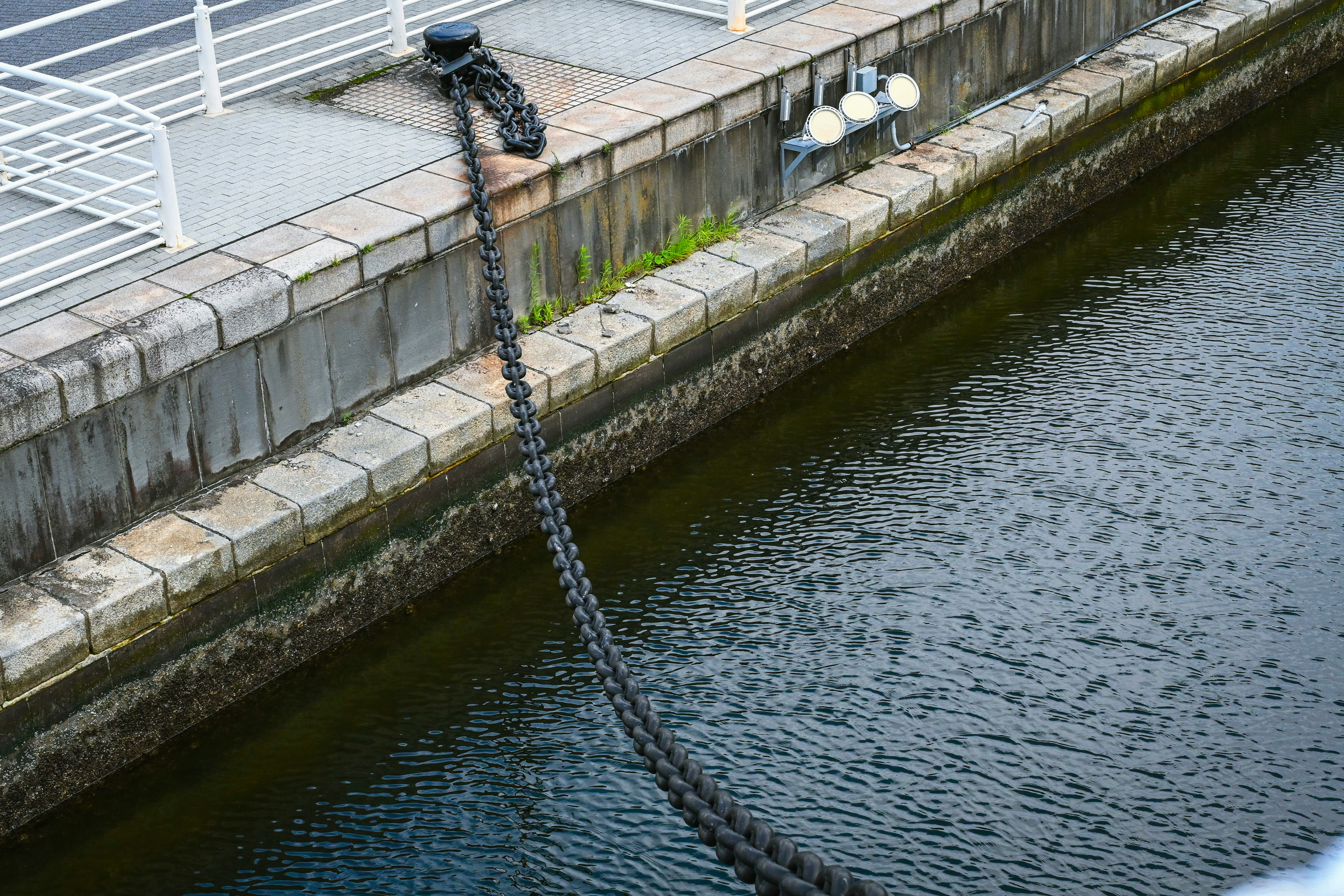 運河沿いの石積みの護岸と鎖でつながれた係留