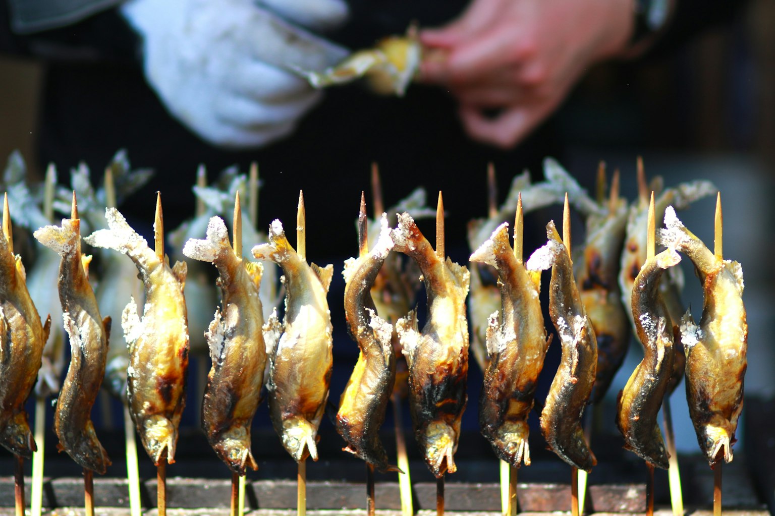 Brochetas de pescado a la parrilla expuestas en un puesto de comida