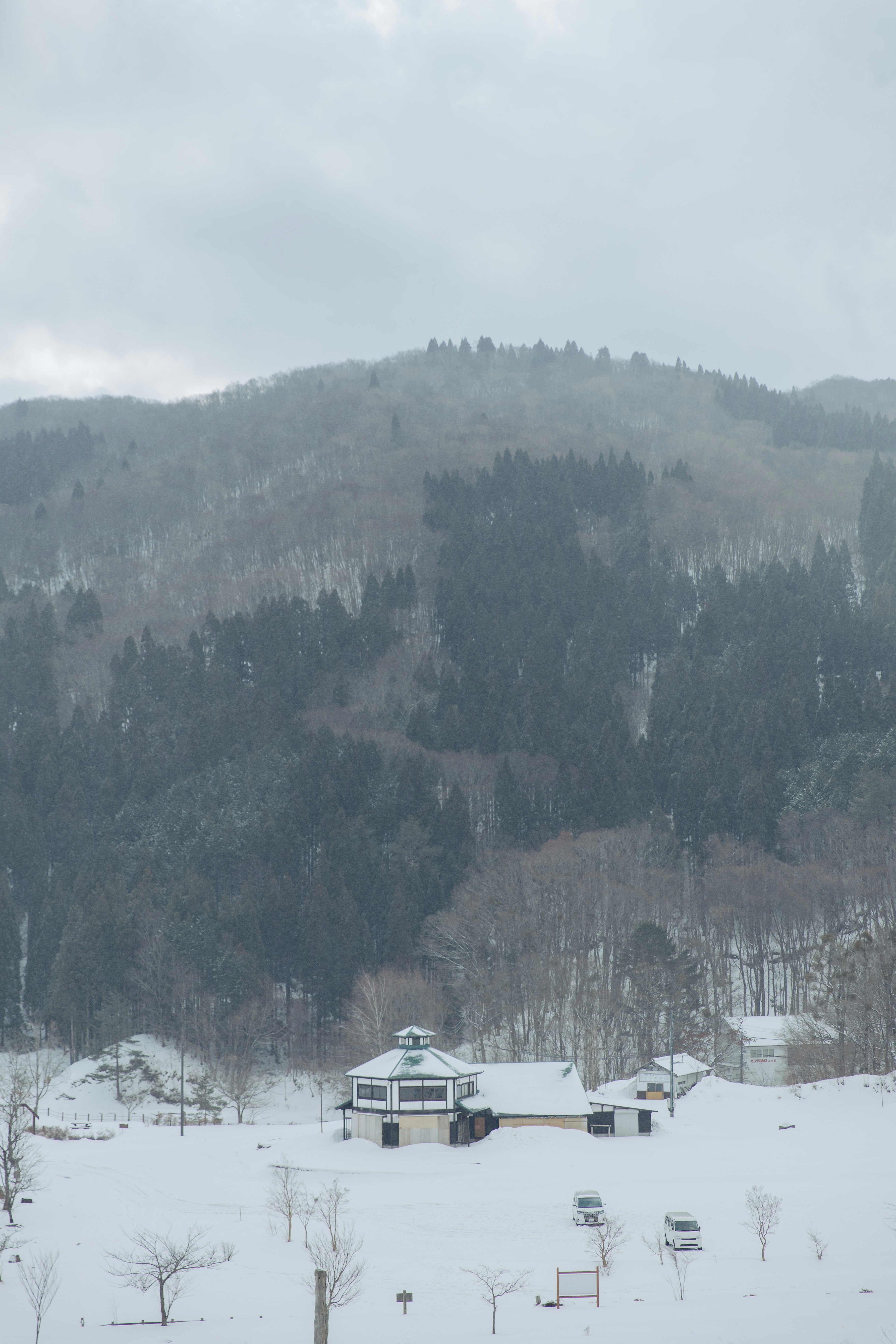 雪原に点在する小屋と山並みの風景