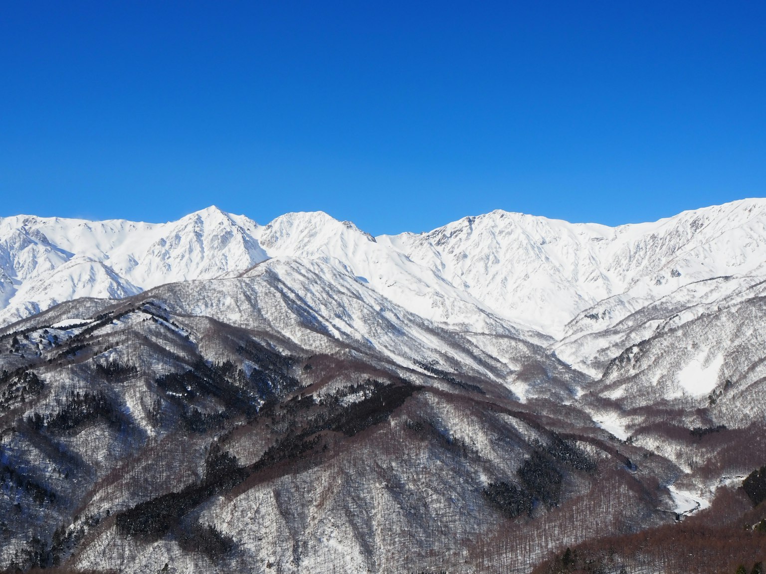 Schneebedeckte Berge unter einem klaren blauen Himmel