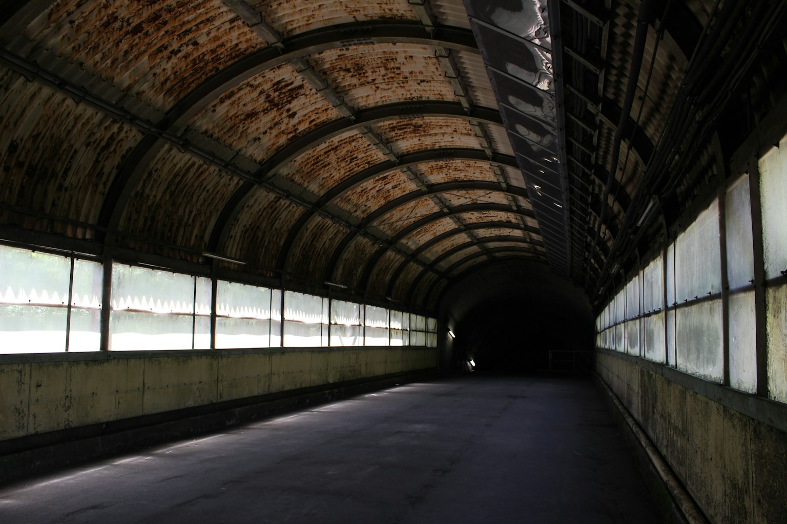 Innenraum eines langen Tunnels mit abgenutzten Backsteinwänden natürliches Licht strömt durch die Fenster