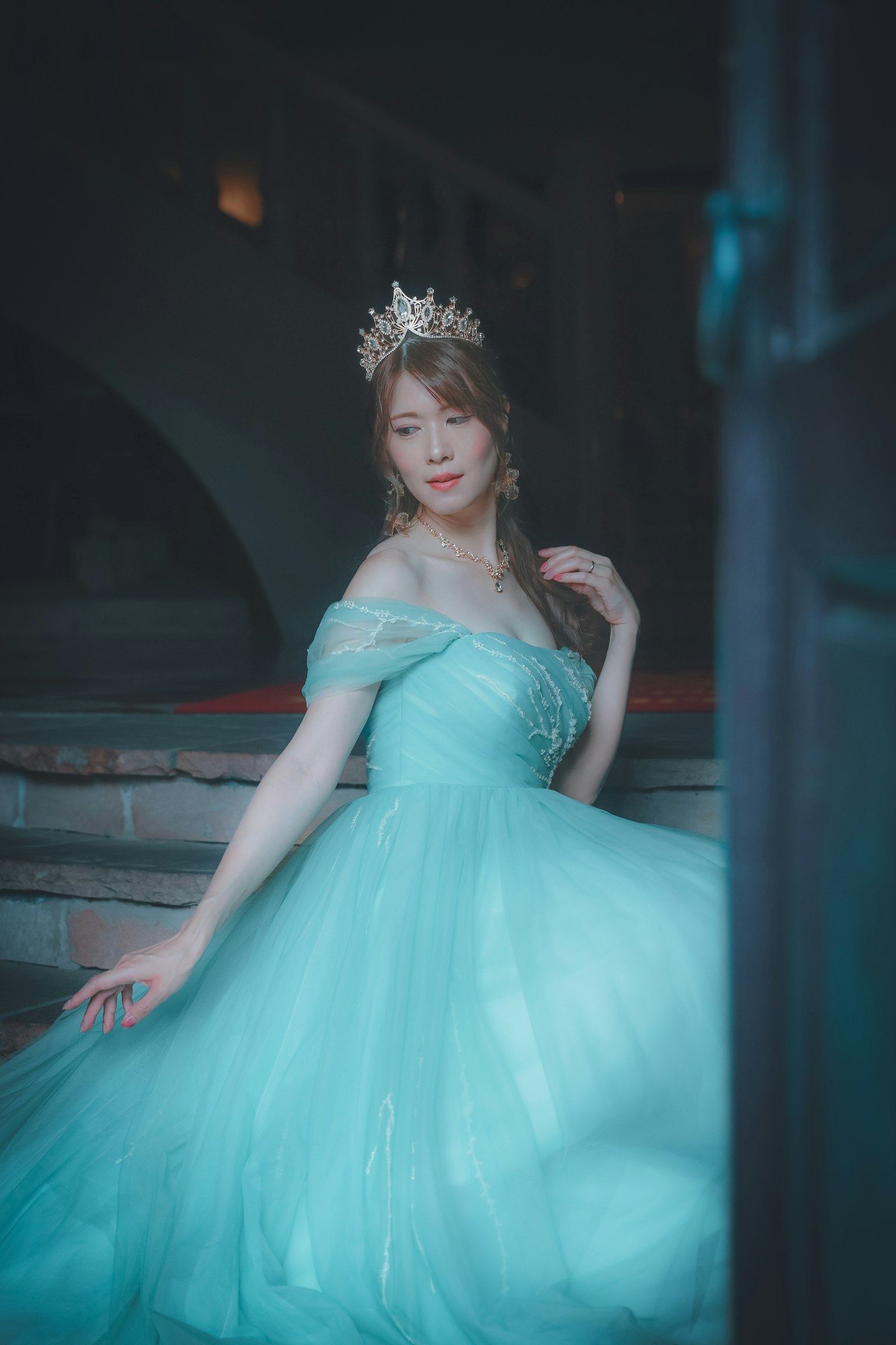 ผู้หญิงในชุดสีน้ำเงินนั่งอยู่บนบันได