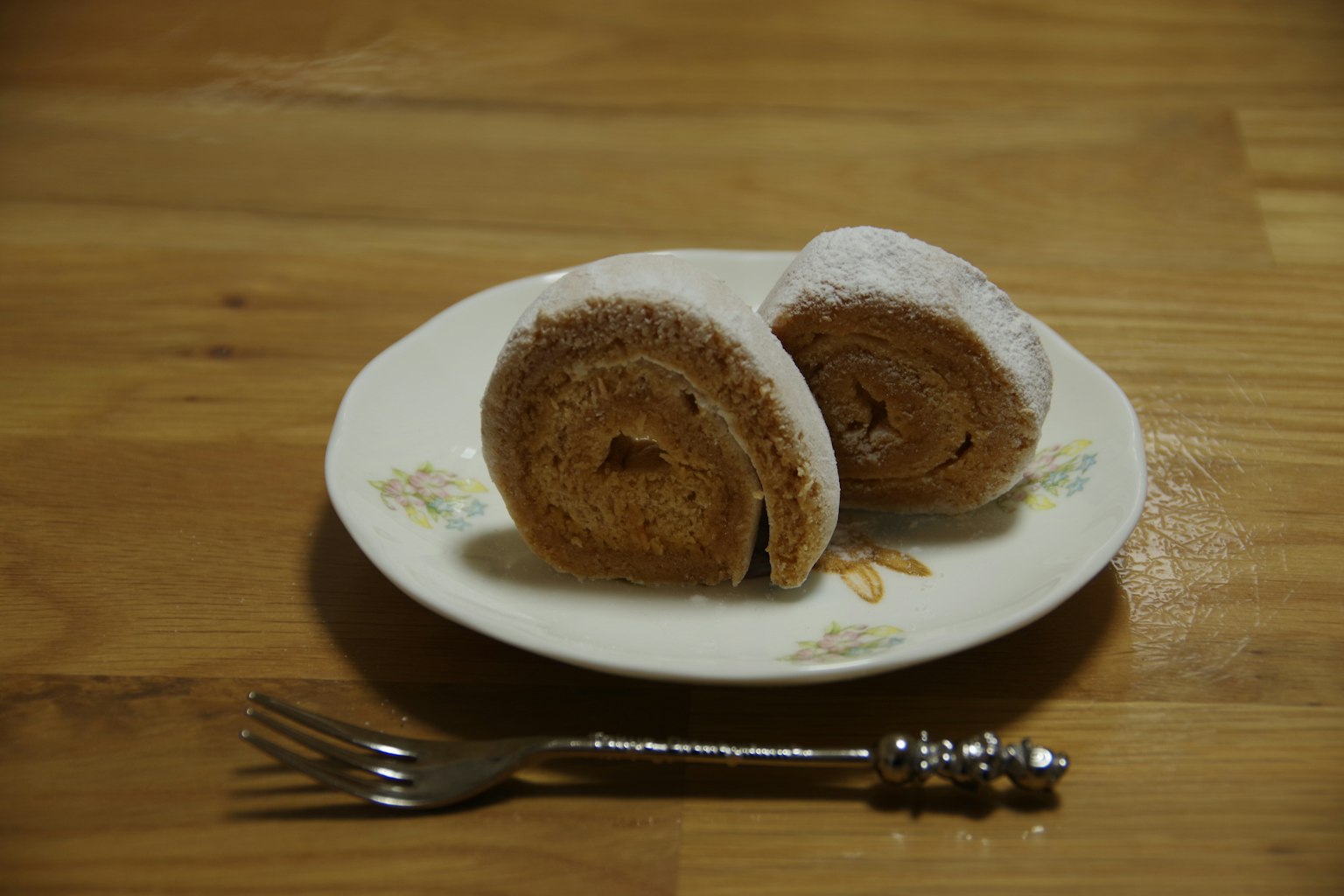 Deux morceaux de gâteau roulé sur une assiette avec une fourchette