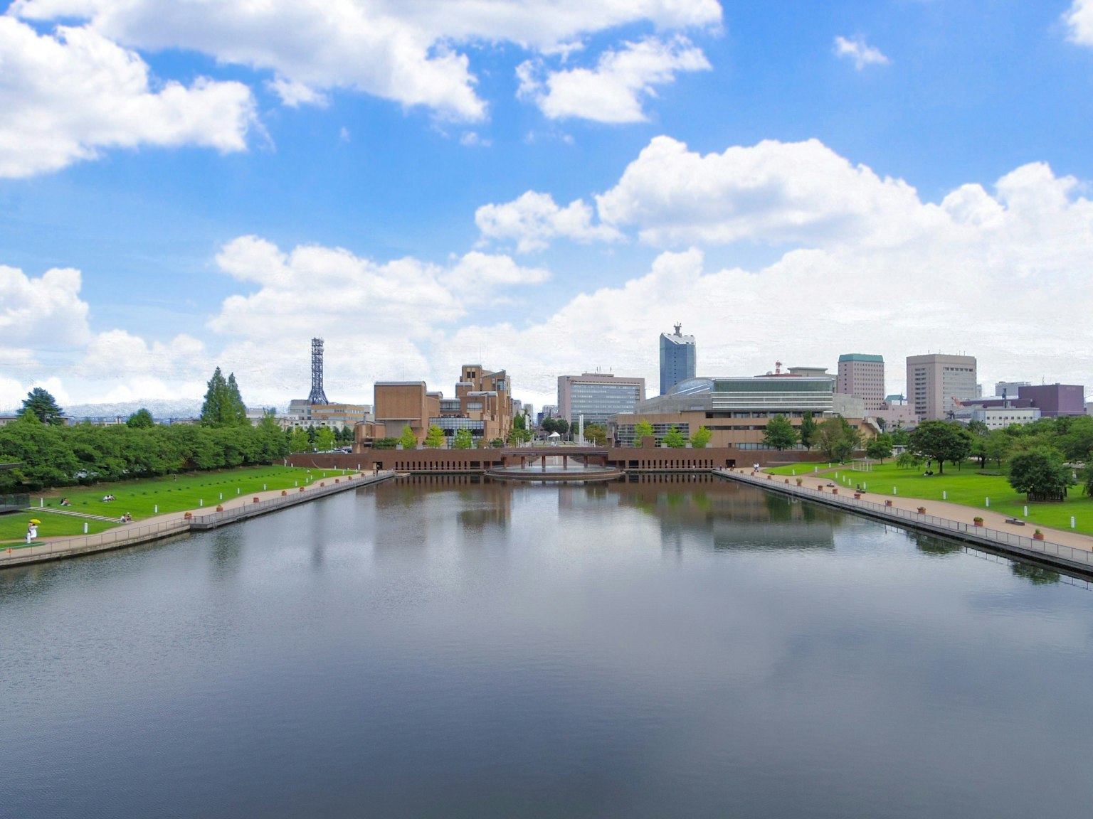Stadtlandschaft unter einem blauen Himmel mit Wolken, die sich im Wasser und grünen Park spiegeln