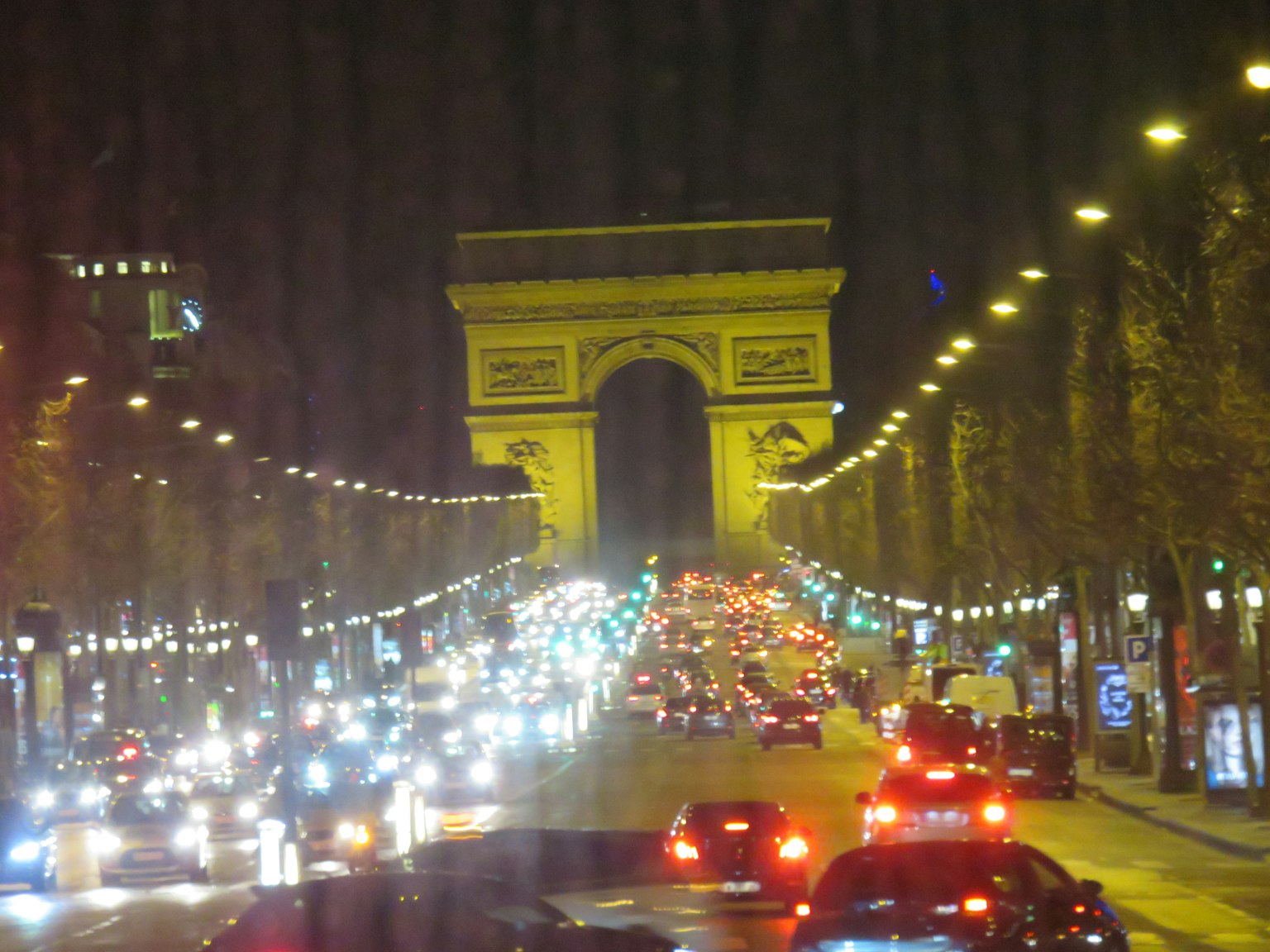 Pemandangan malam Arc de Triomphe dengan lalu lintas di Champs-Élysées