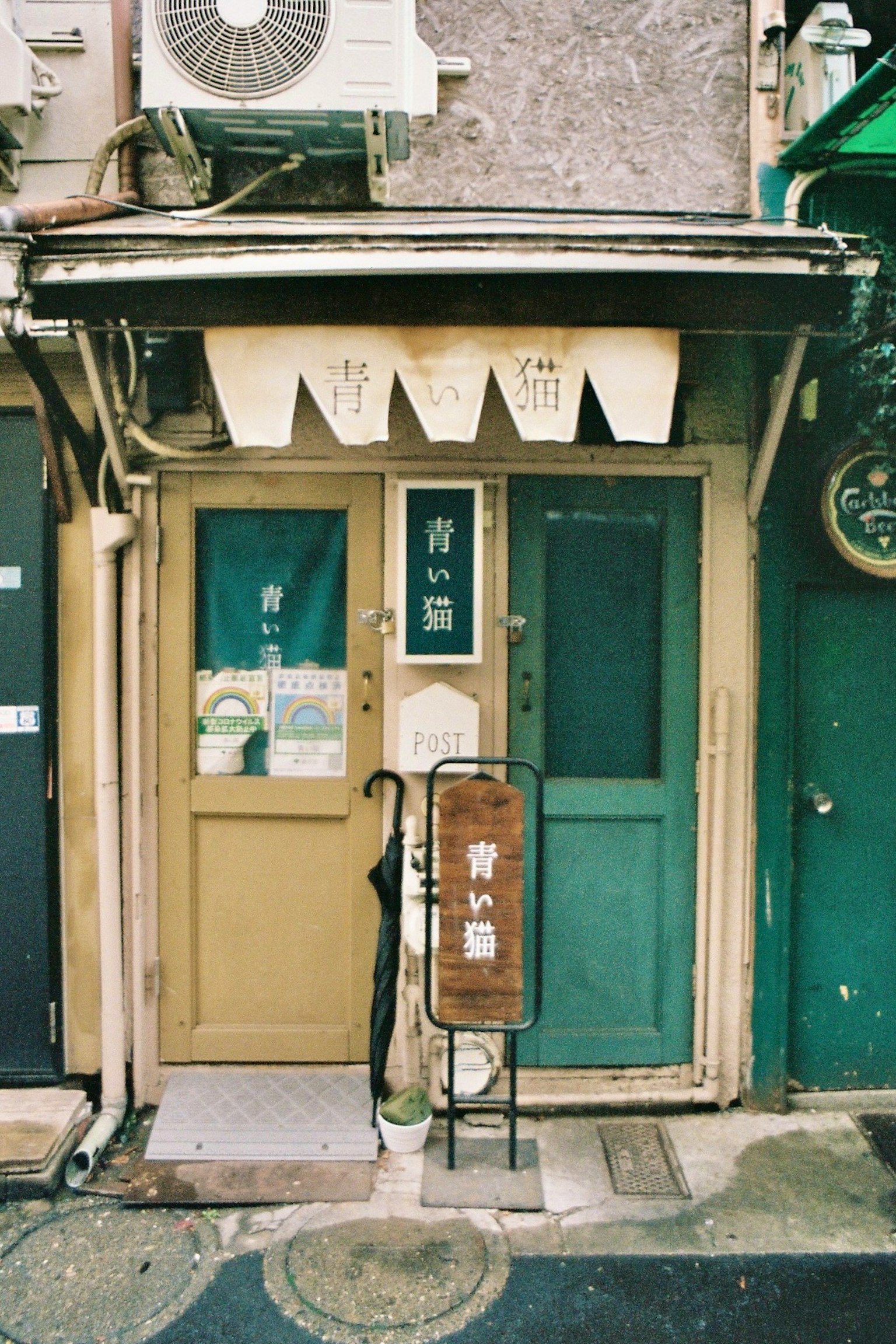 老式日本商店外觀，綠色和棕色的門，傳統招牌