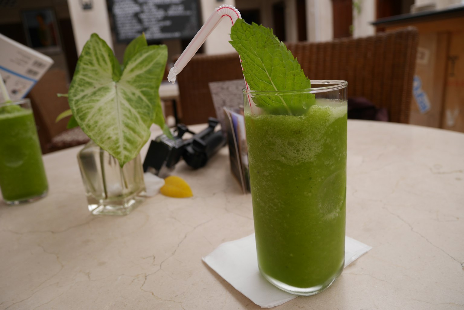 Ein grünes Getränk in einem Glas mit frischen Minzblättern serviert