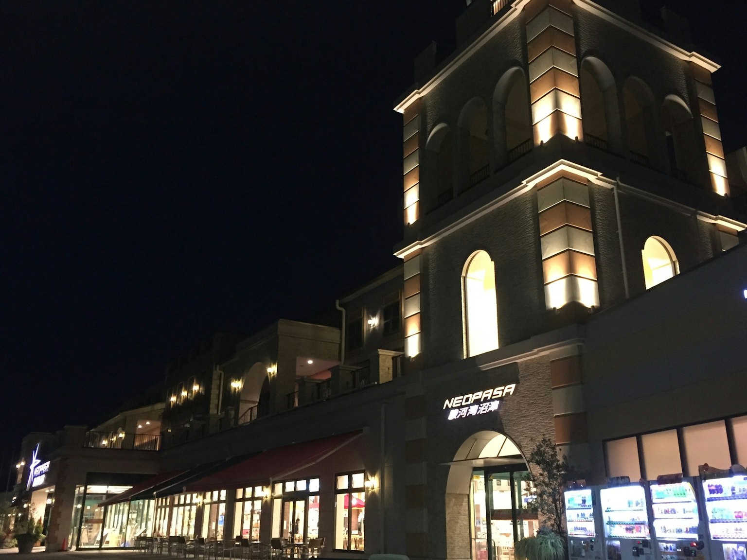 Esterno di un edificio commerciale di notte con luci brillanti