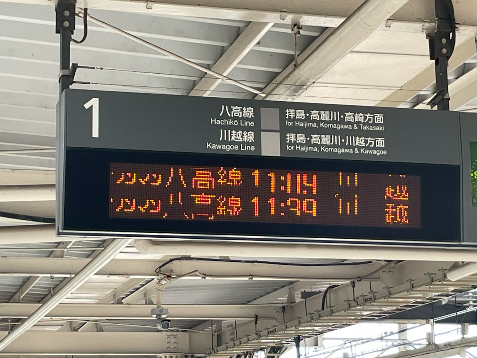 Tabellone delle partenze che mostra gli orari della linea Hachiko e del treno per Hachioji 11:14 e 11:39