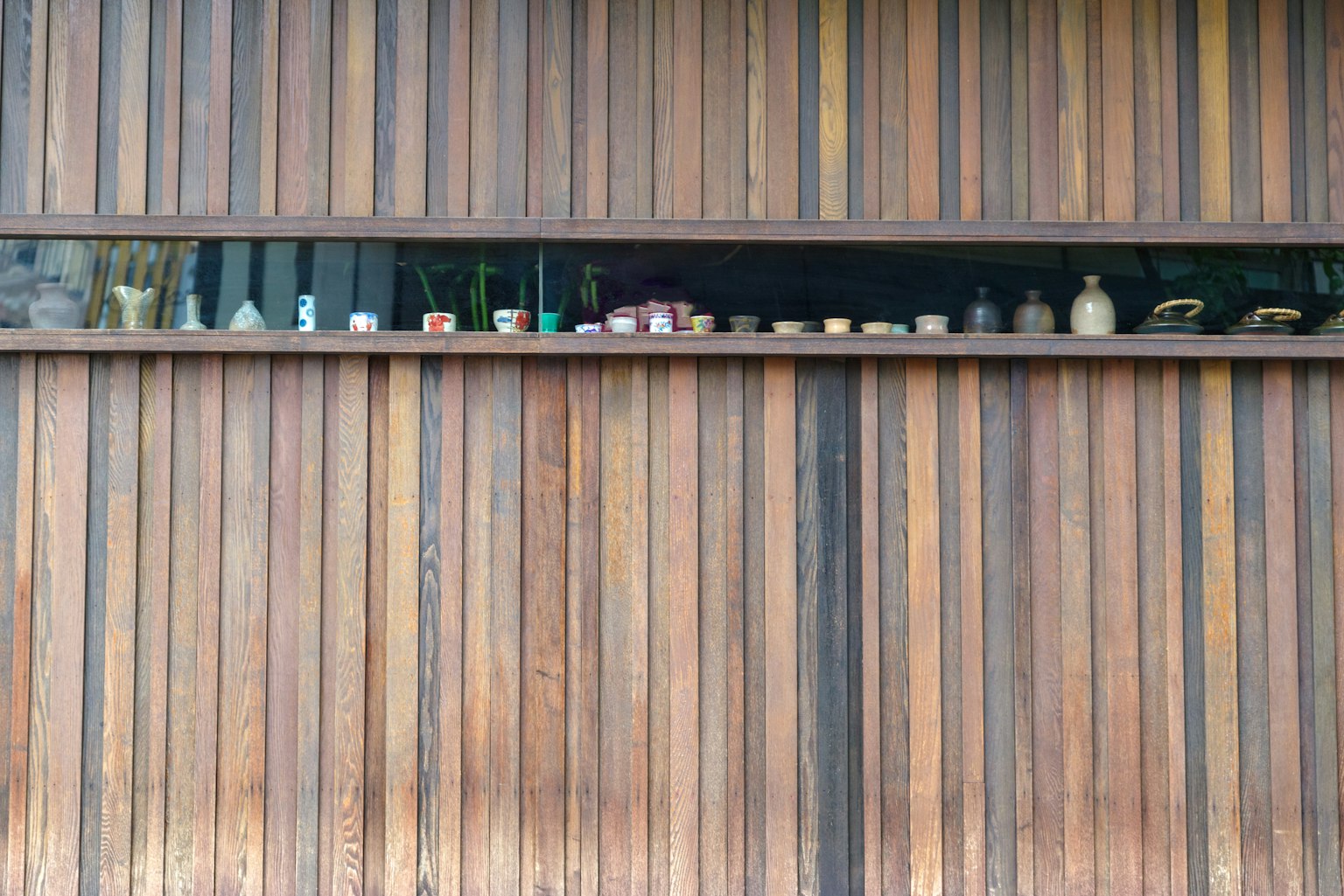Various bottles and objects arranged on a wooden wall shelf