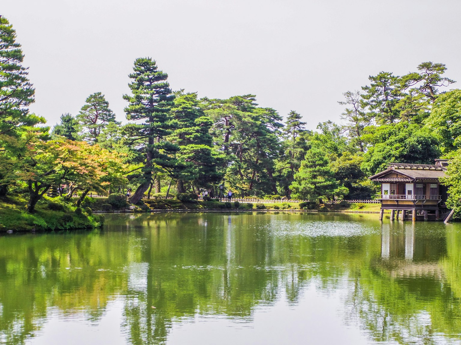 静かな池と緑豊かな木々の風景に囲まれた伝統的な建物