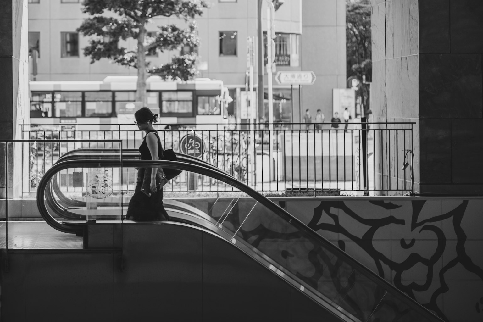 Una persona che scende una scala mobile con uno sfondo urbano