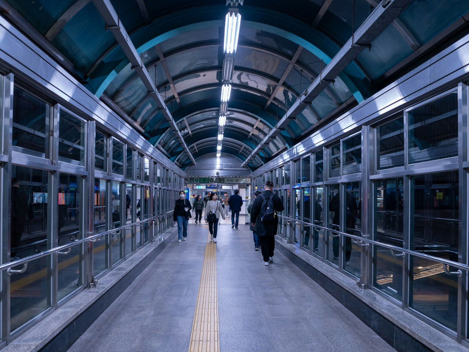 現代的な駅の通路で人々が歩いている様子