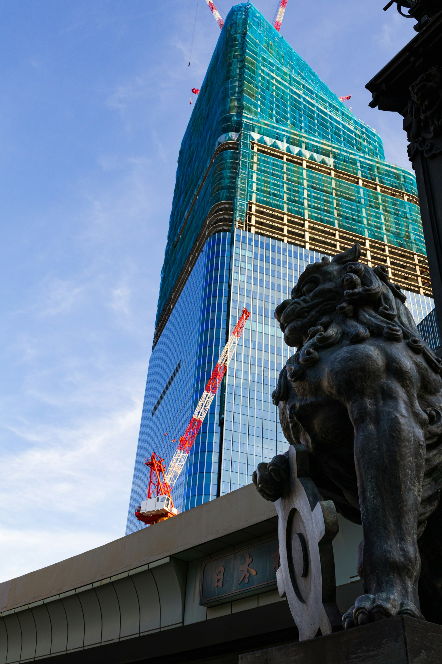 高層建築的施工與前景的獅子雕像