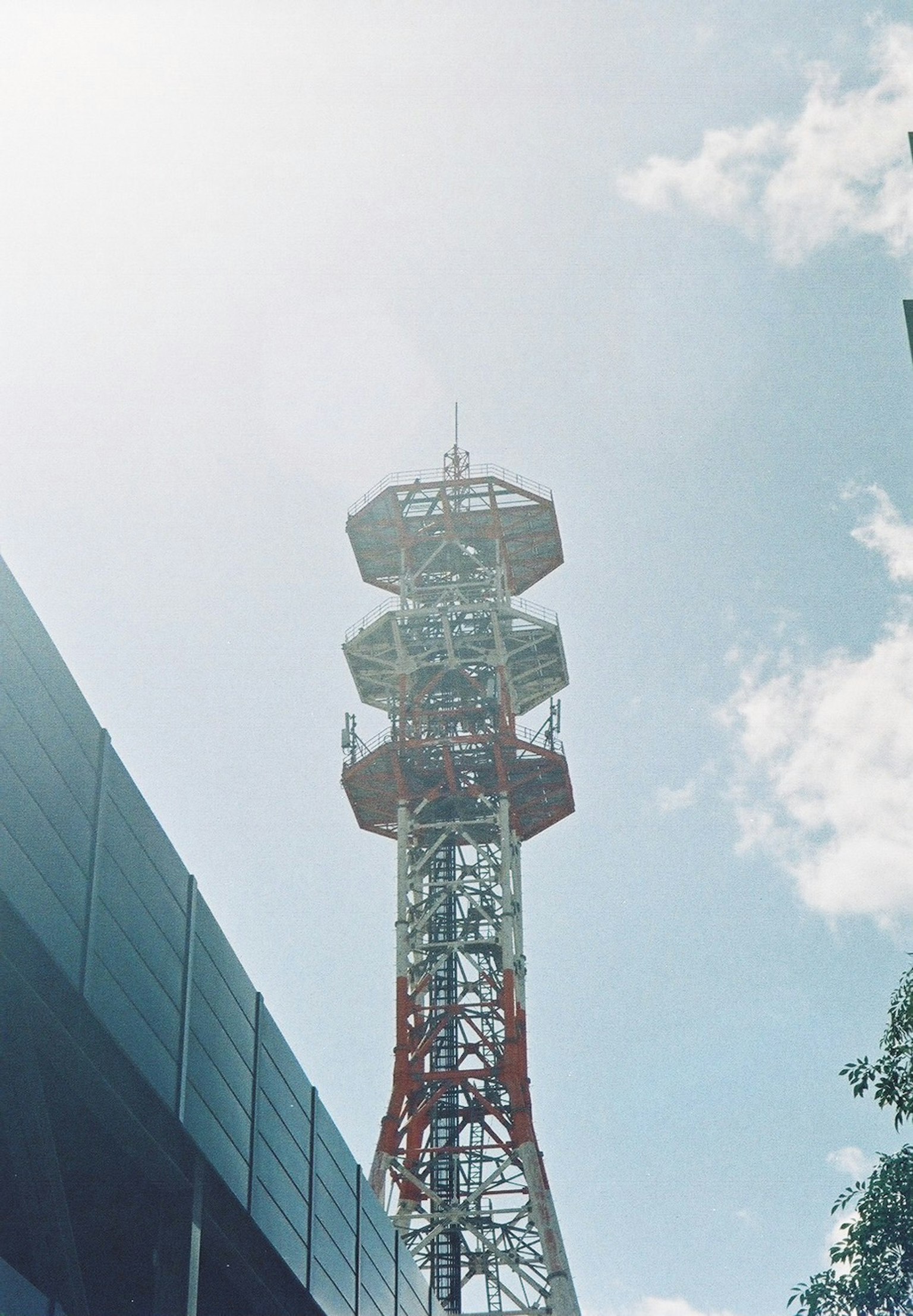 Foto menara komunikasi yang menjulang di bawah langit biru