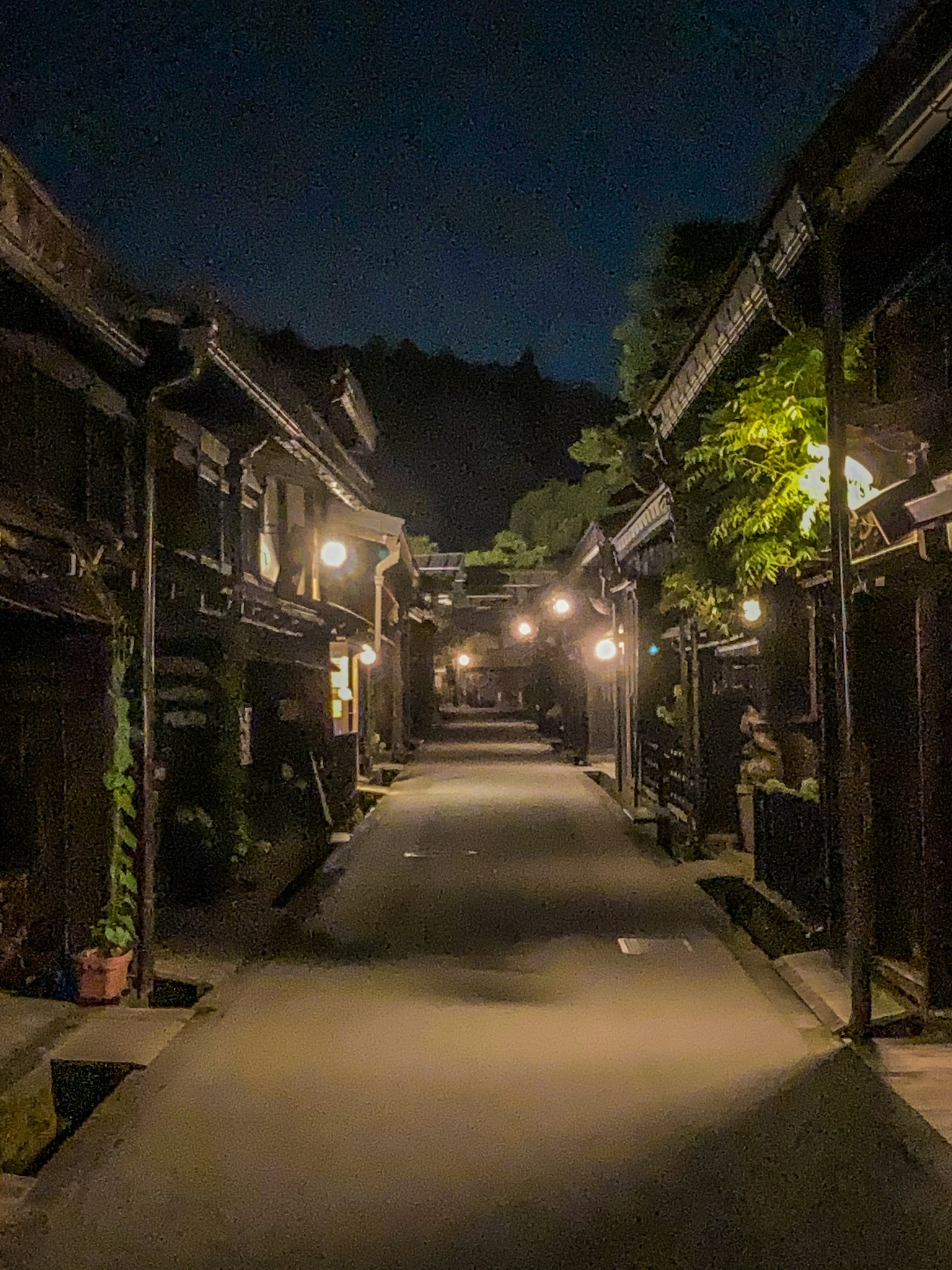 Strada di una vecchia città tranquilla illuminata da lampioni di notte