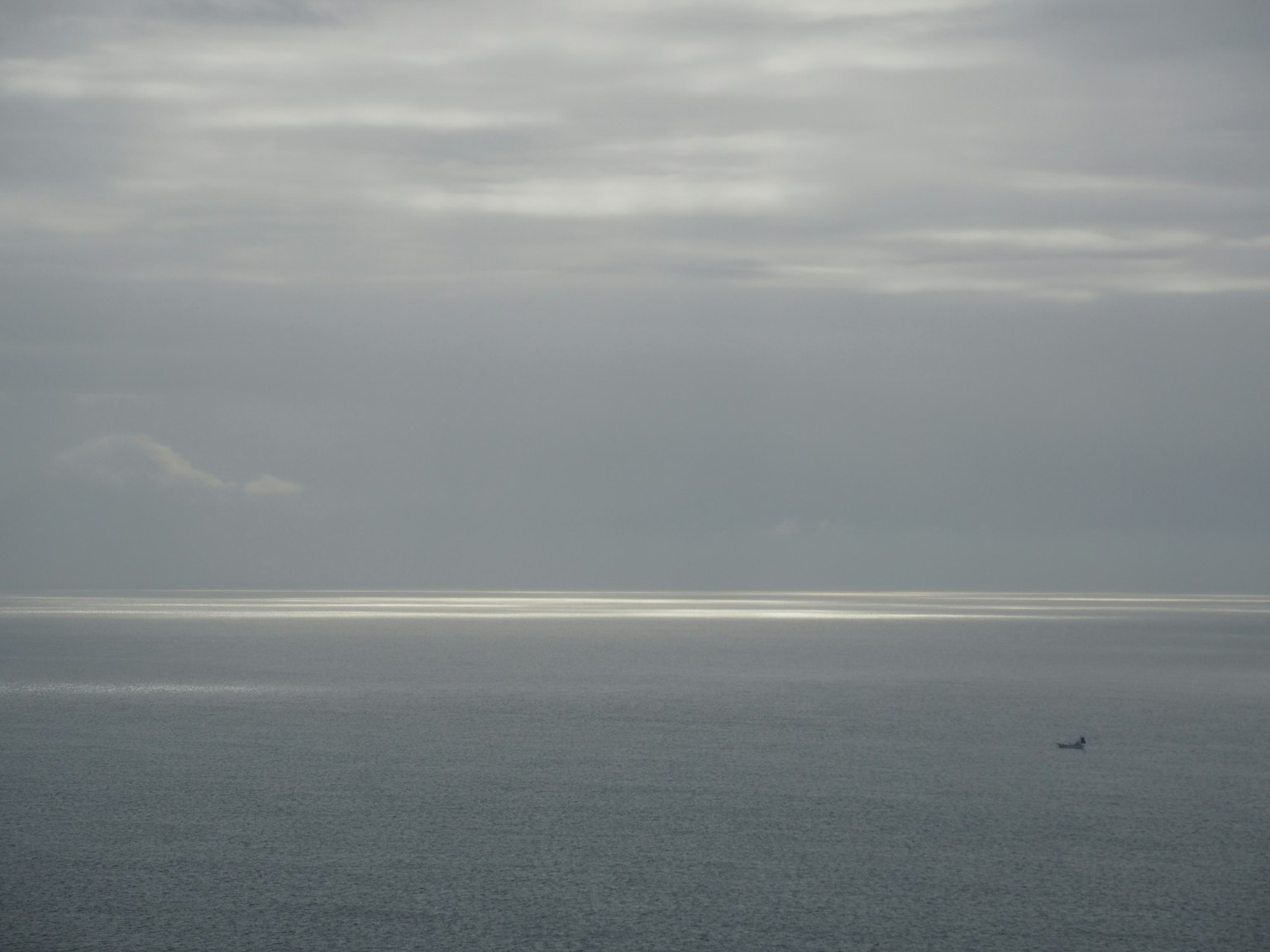 曇り空の下の海の景色と小さな船