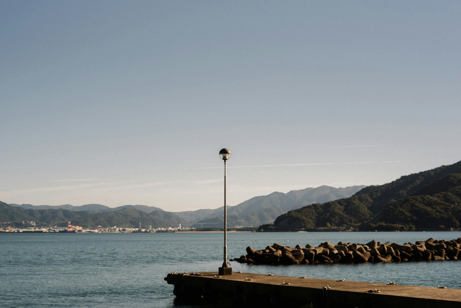 Une belle vue de la mer et des montagnes avec un phare