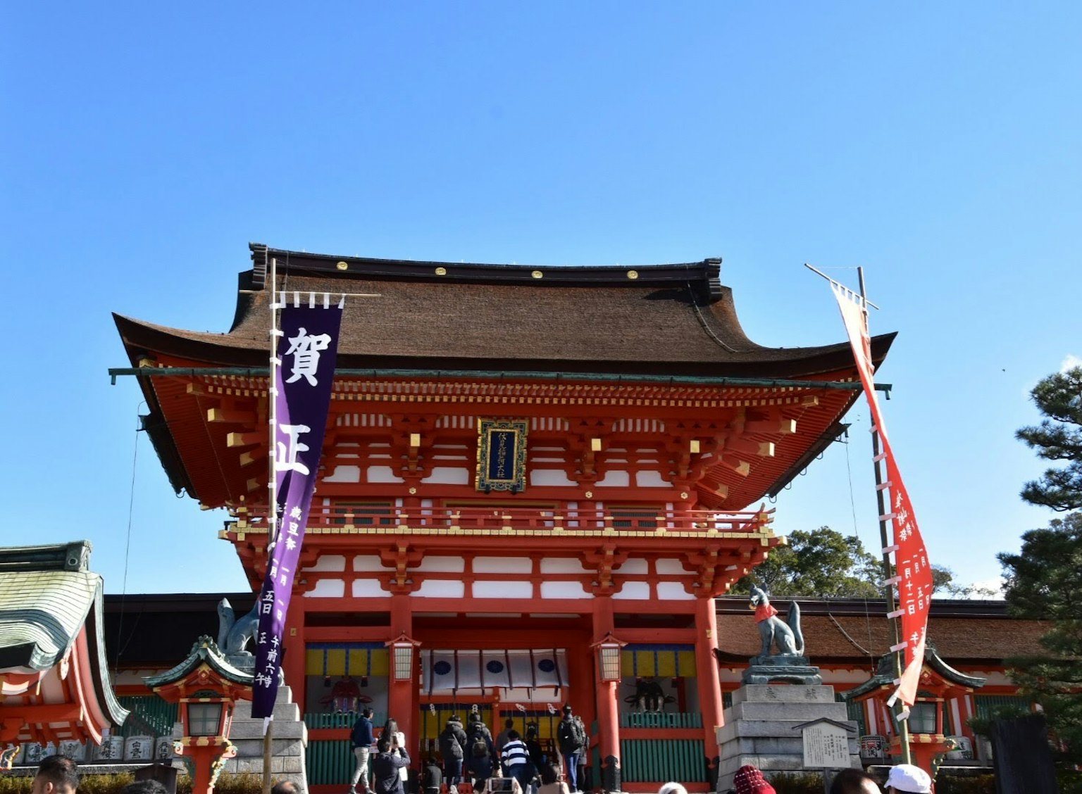 在晴朗蓝天下聚集人们的美丽红色神社建筑
