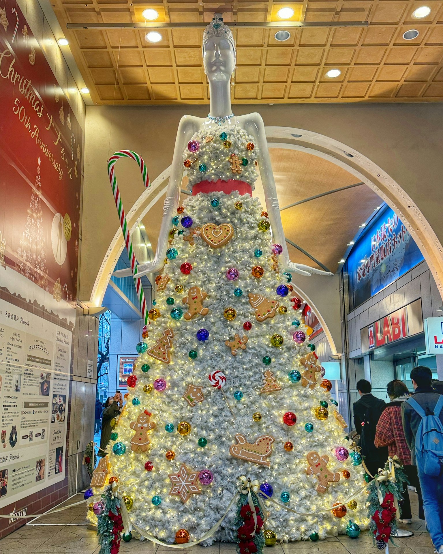 Gran árbol de Navidad en forma de vestido adornado con decoraciones coloridas