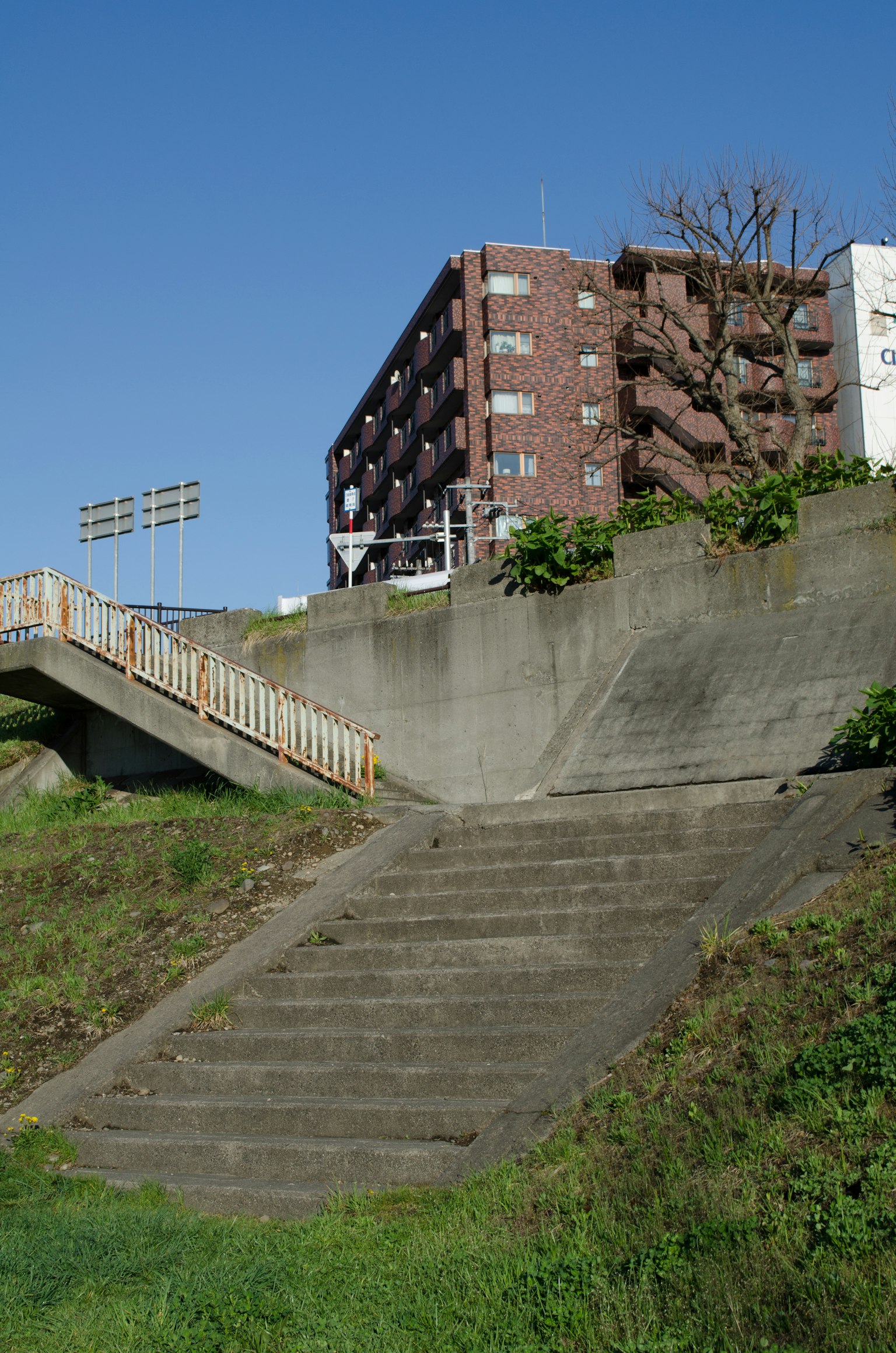Escaliers menant à un bâtiment avec un ciel bleu clair et de l'herbe verte