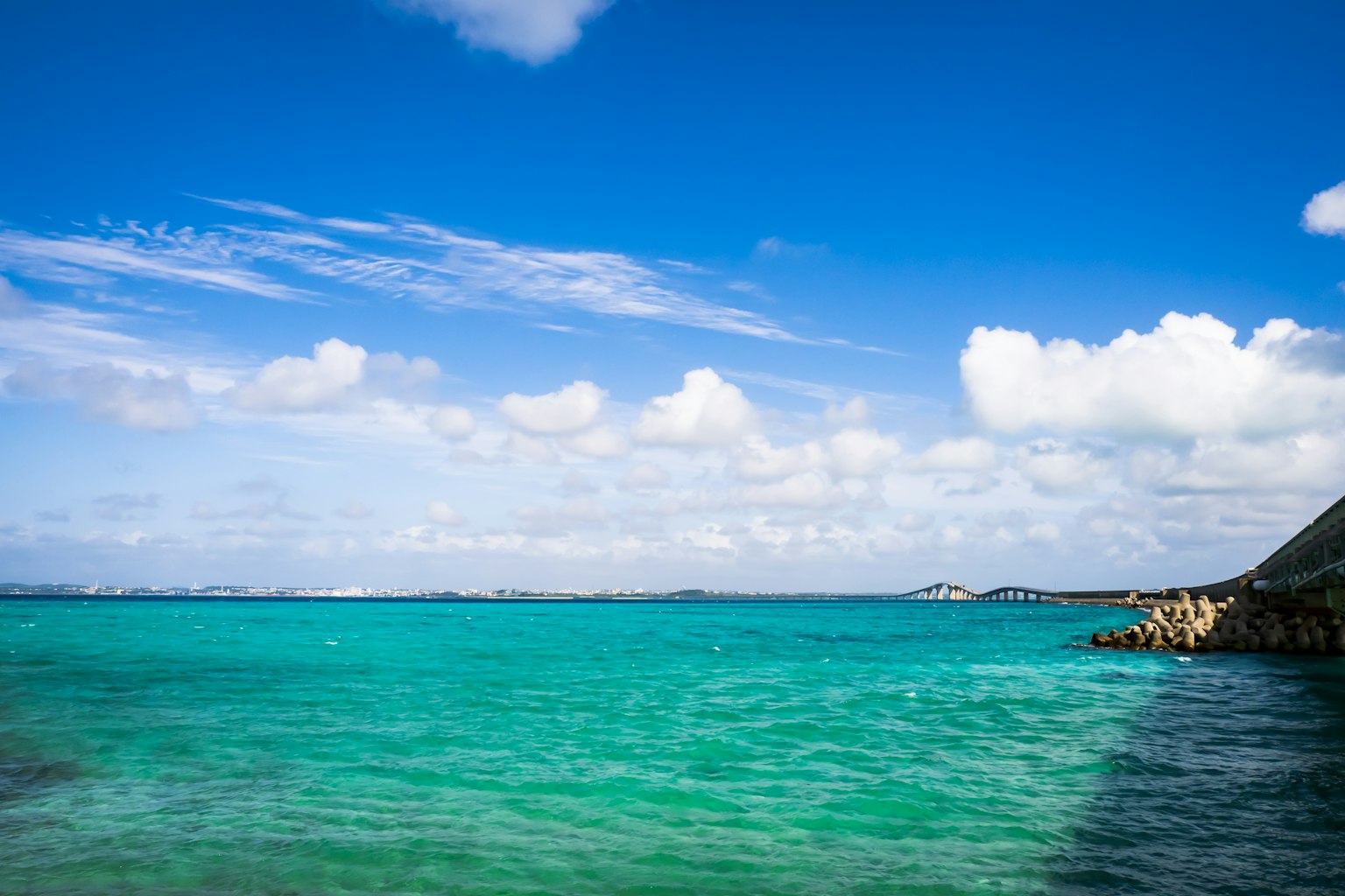 Schöne Landschaft mit blauem Meer und Himmel sowie Küste und weißen Wolken