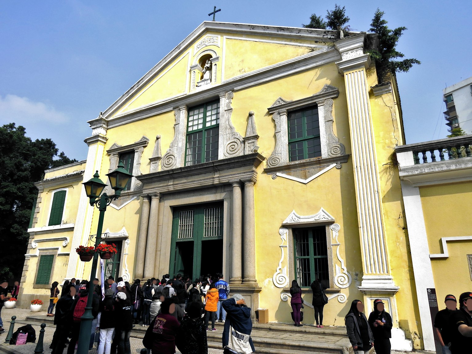 Historisches Gebäude mit gelber Fassade und Menschenmenge