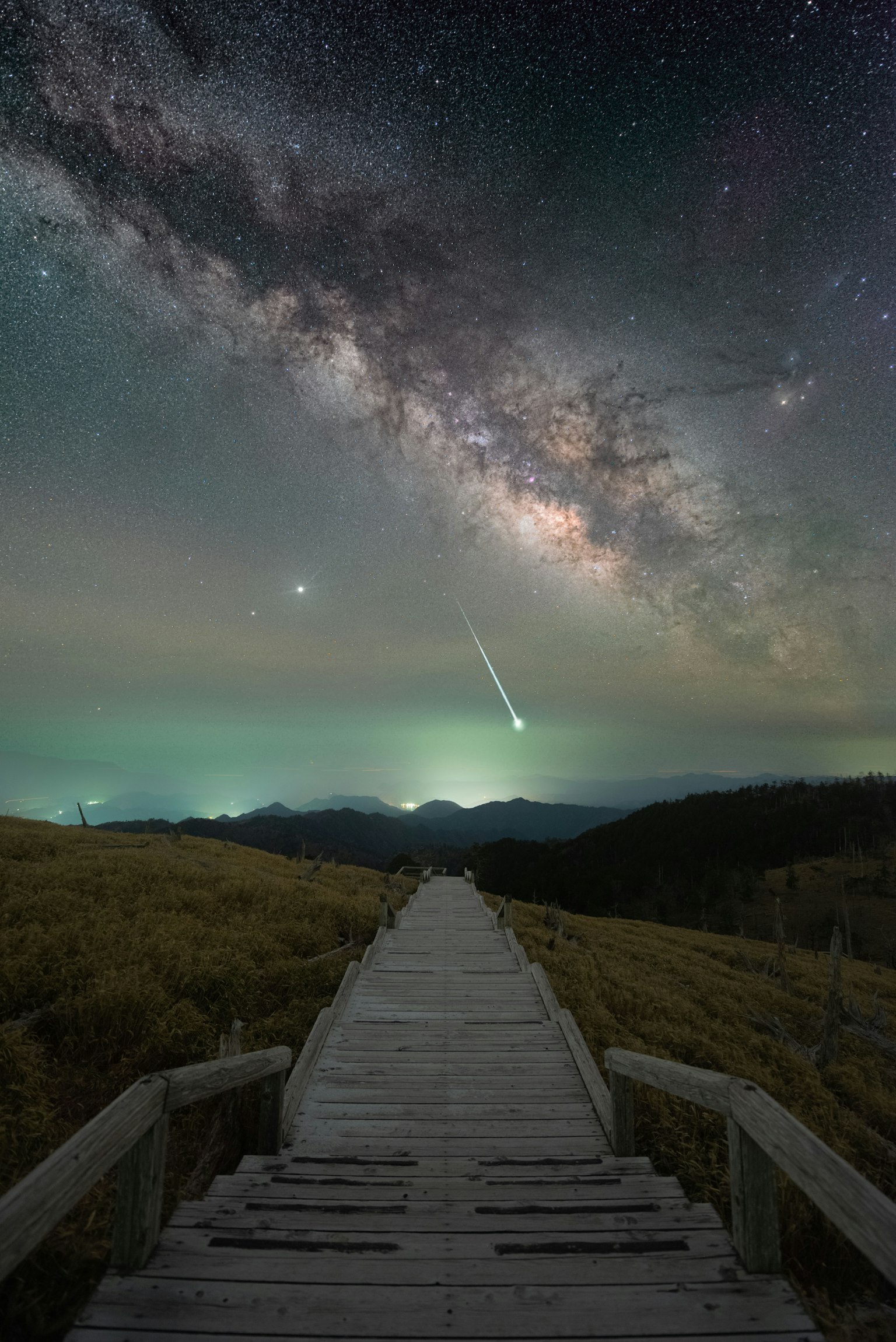 Sentiero di legno sotto un cielo stellato con una vista mozzafiato della Via Lattea