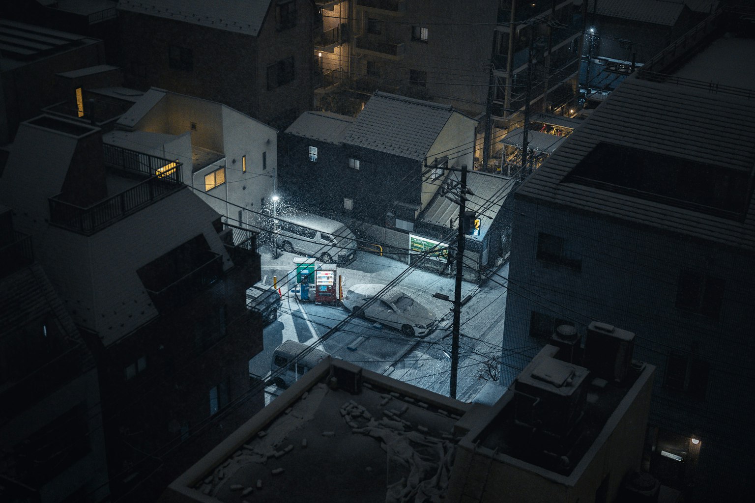 Vista nocturna de una calle urbana cubierta de nieve con calles tranquilas y vehículos