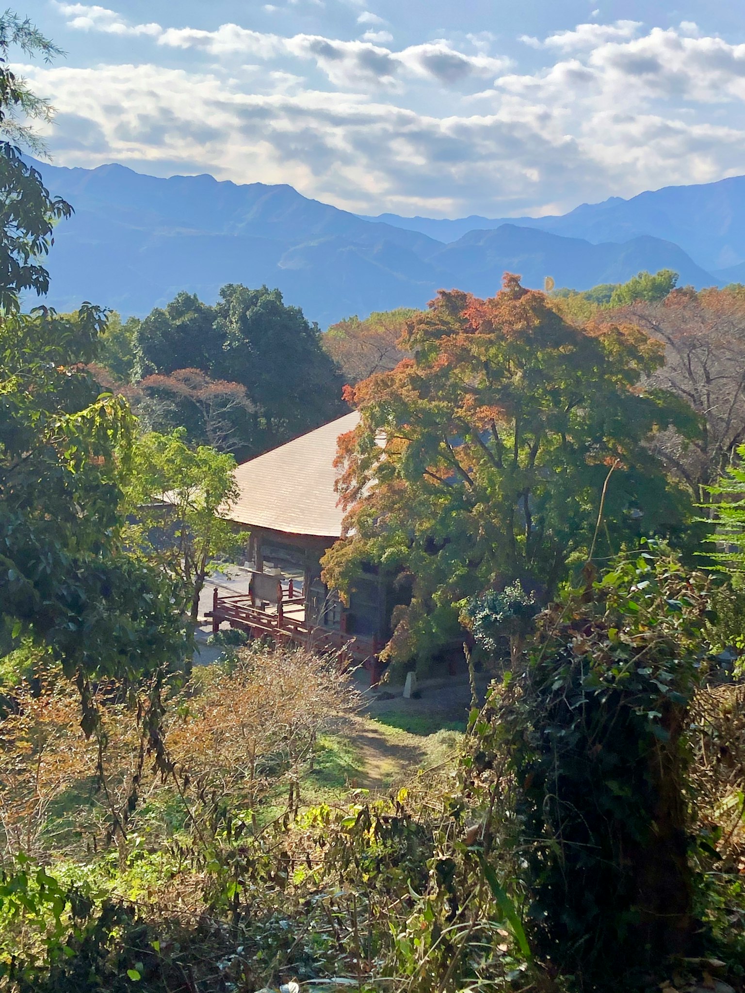 Casa japonesa tradicional en un paisaje rural sereno rodeado de montañas