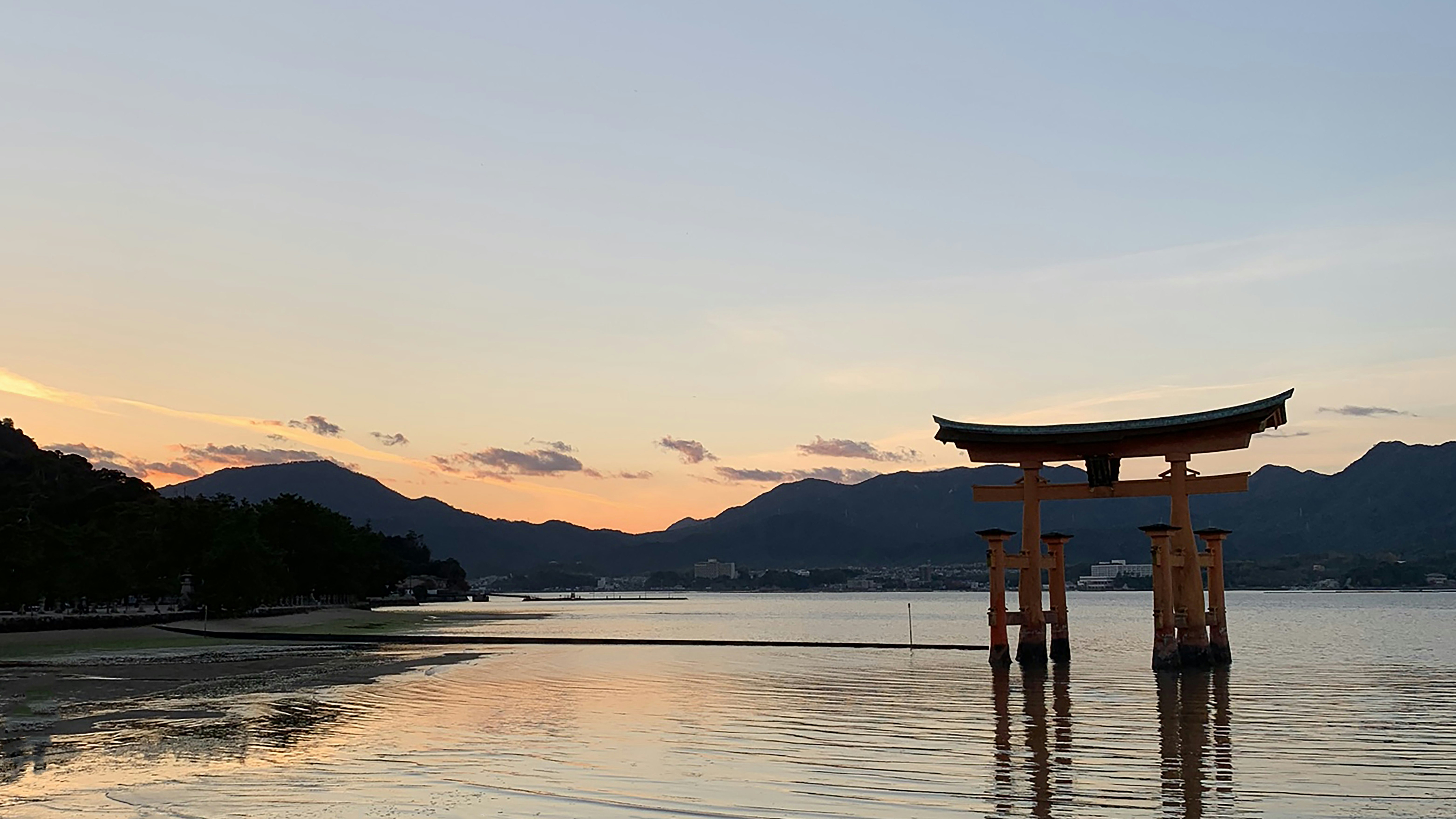 夕暮れの湖畔に立つ鳥居と水面の反射