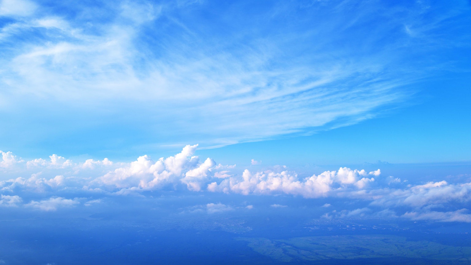 Weitläufiger blauer Himmel mit flauschigen weißen Wolken