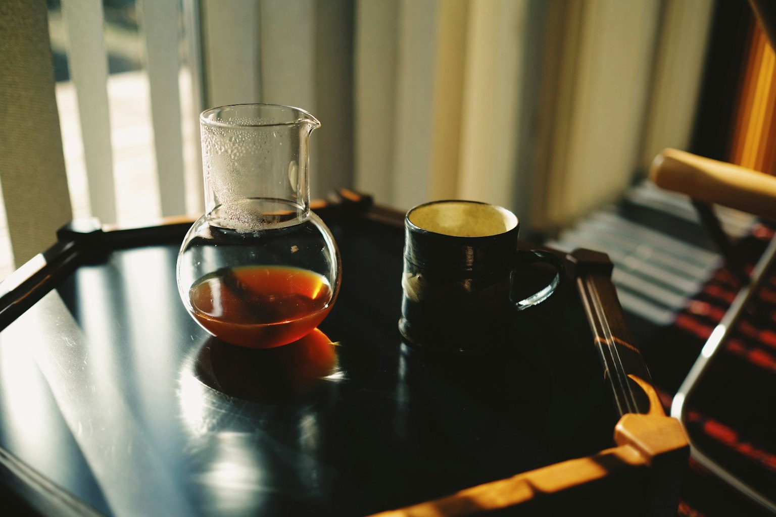 Teapot kaca dan cangkir di atas meja kayu