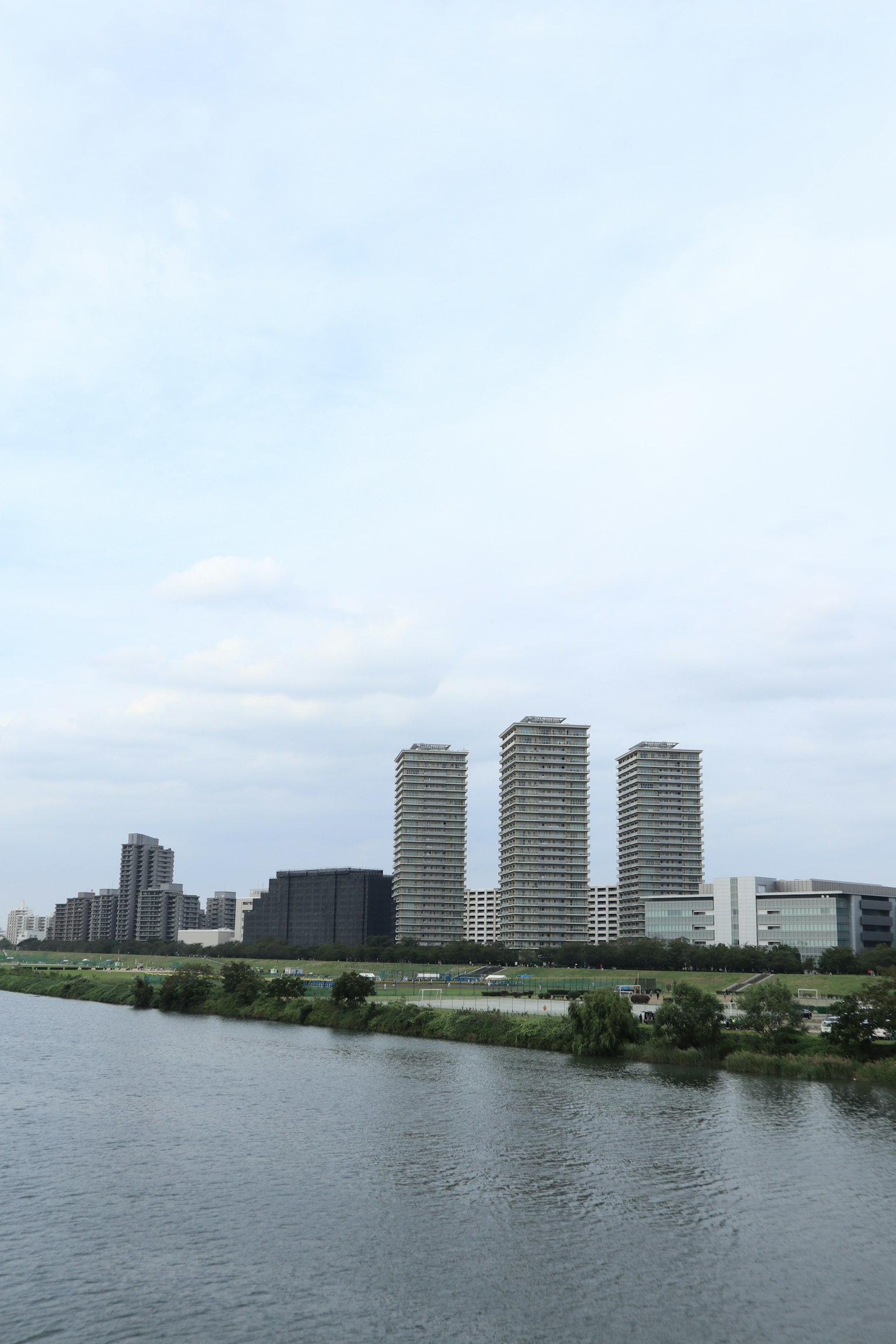 High-rise buildings near a river under a cloudy sky